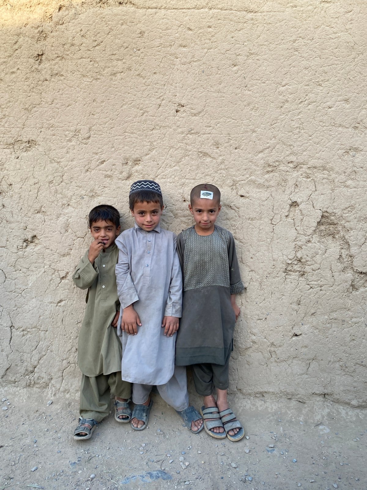 Everyday life near a mud-brick wall in Arghandab, Afghanistan