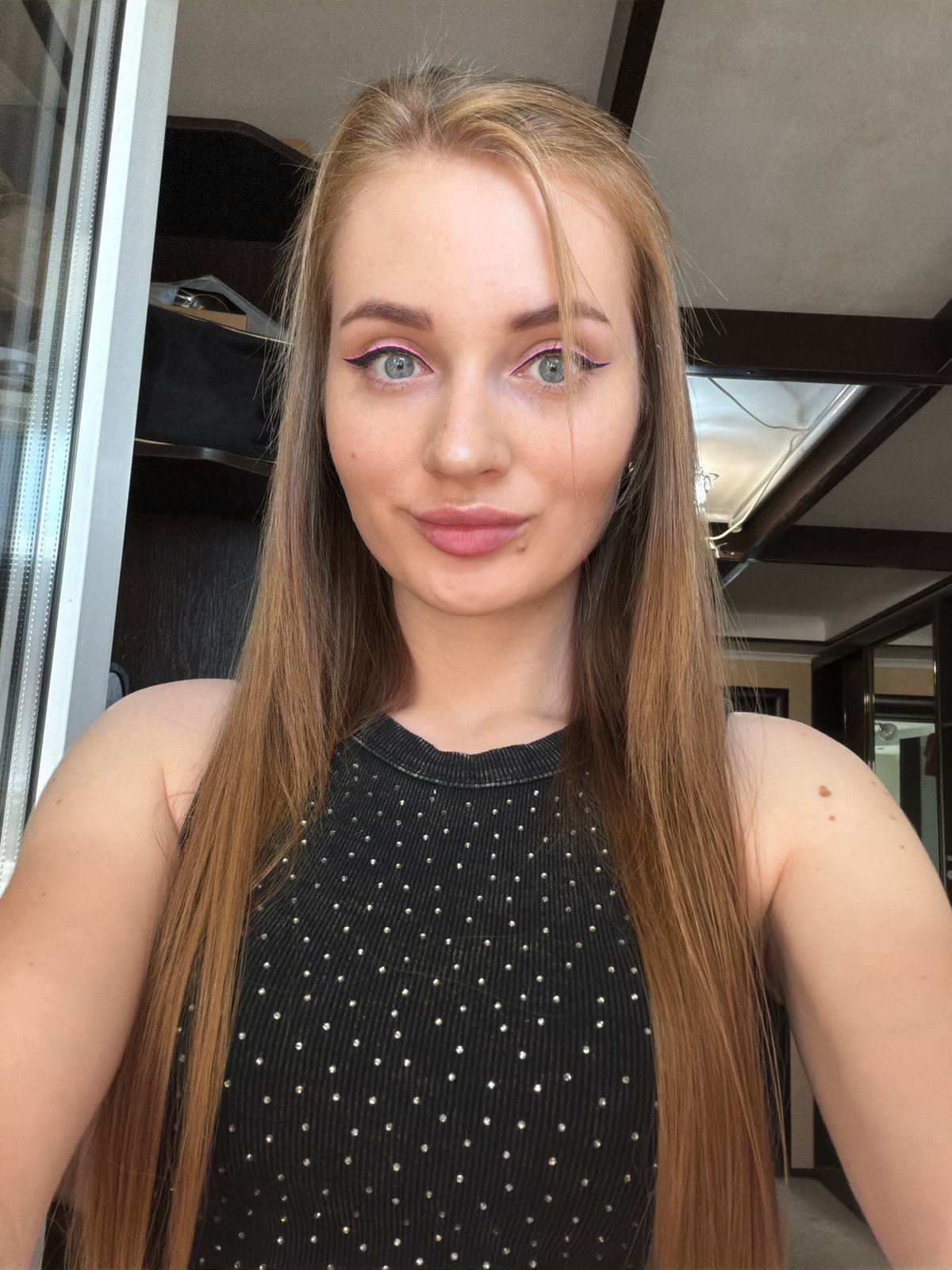 Close-up selfie with studded top and pink eyeliner