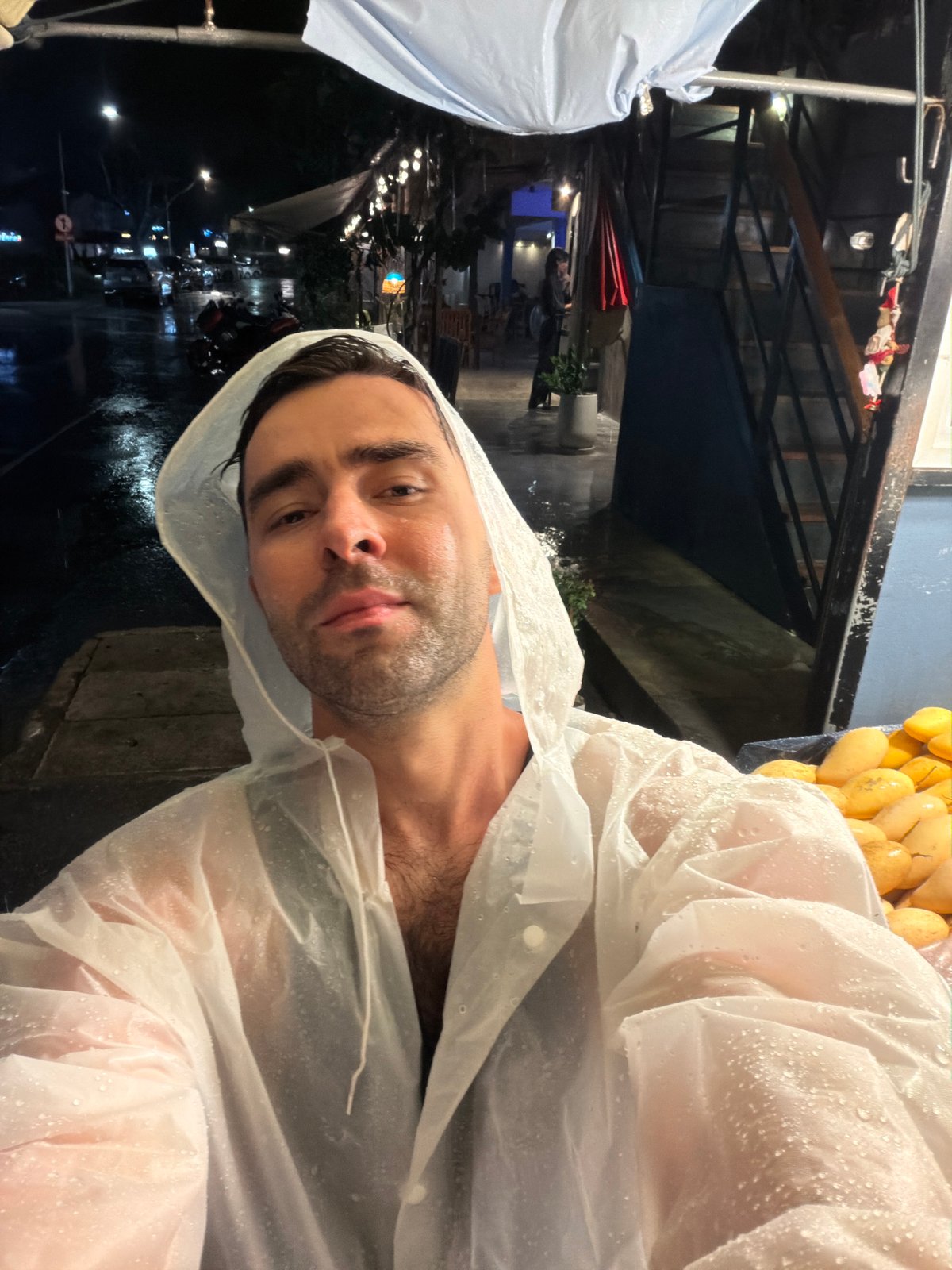 Man in white raincoat photographed on Choeng Thale street