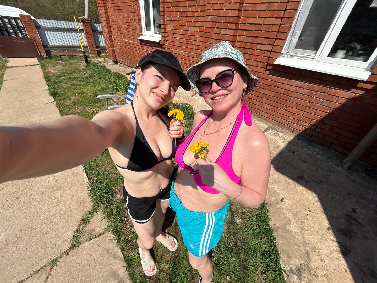 Women sunbathe and photograph outdoors in Rusalevka, Russia