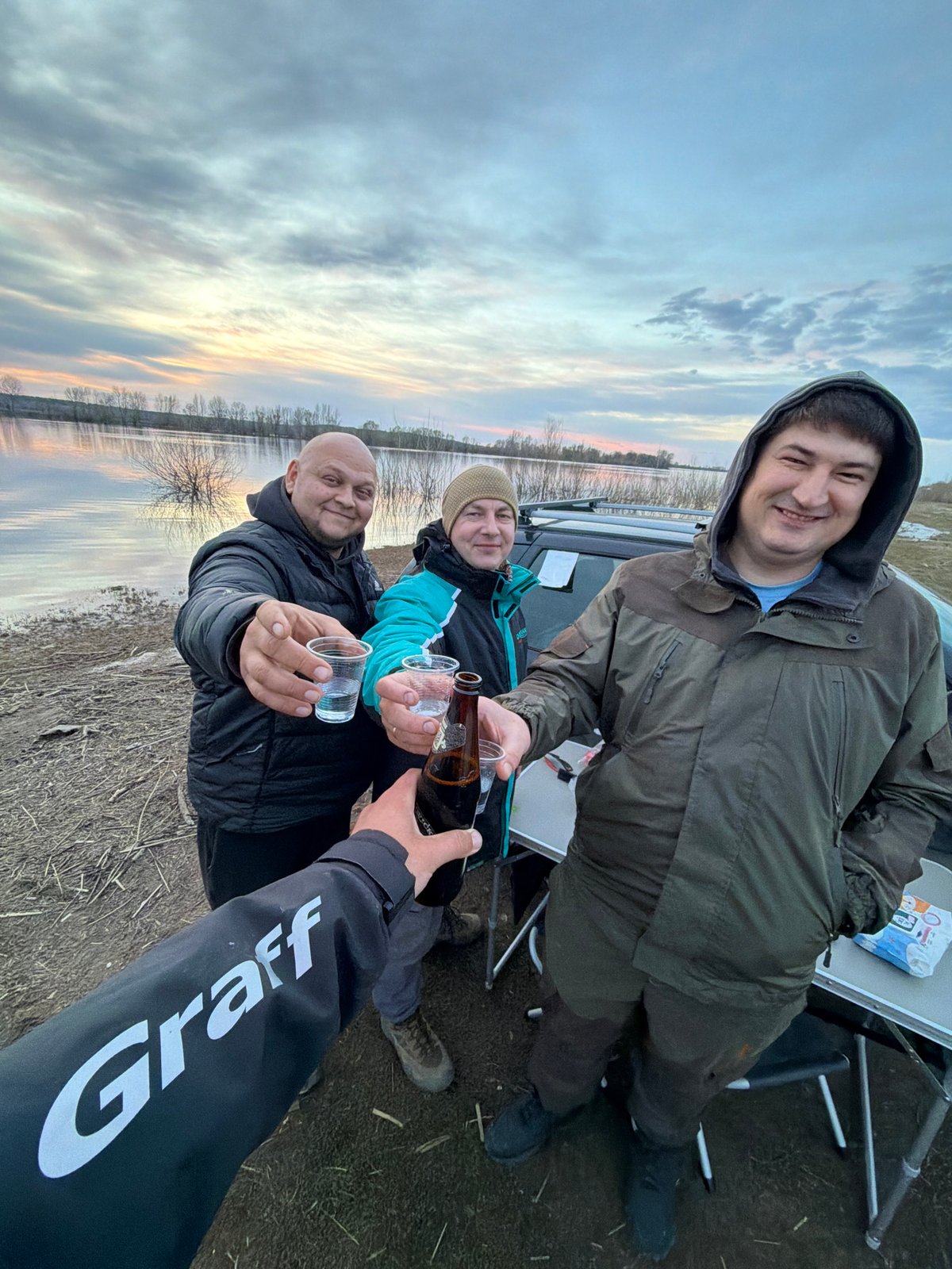 Four people gather near flooded area in Nikolo-Berezovka