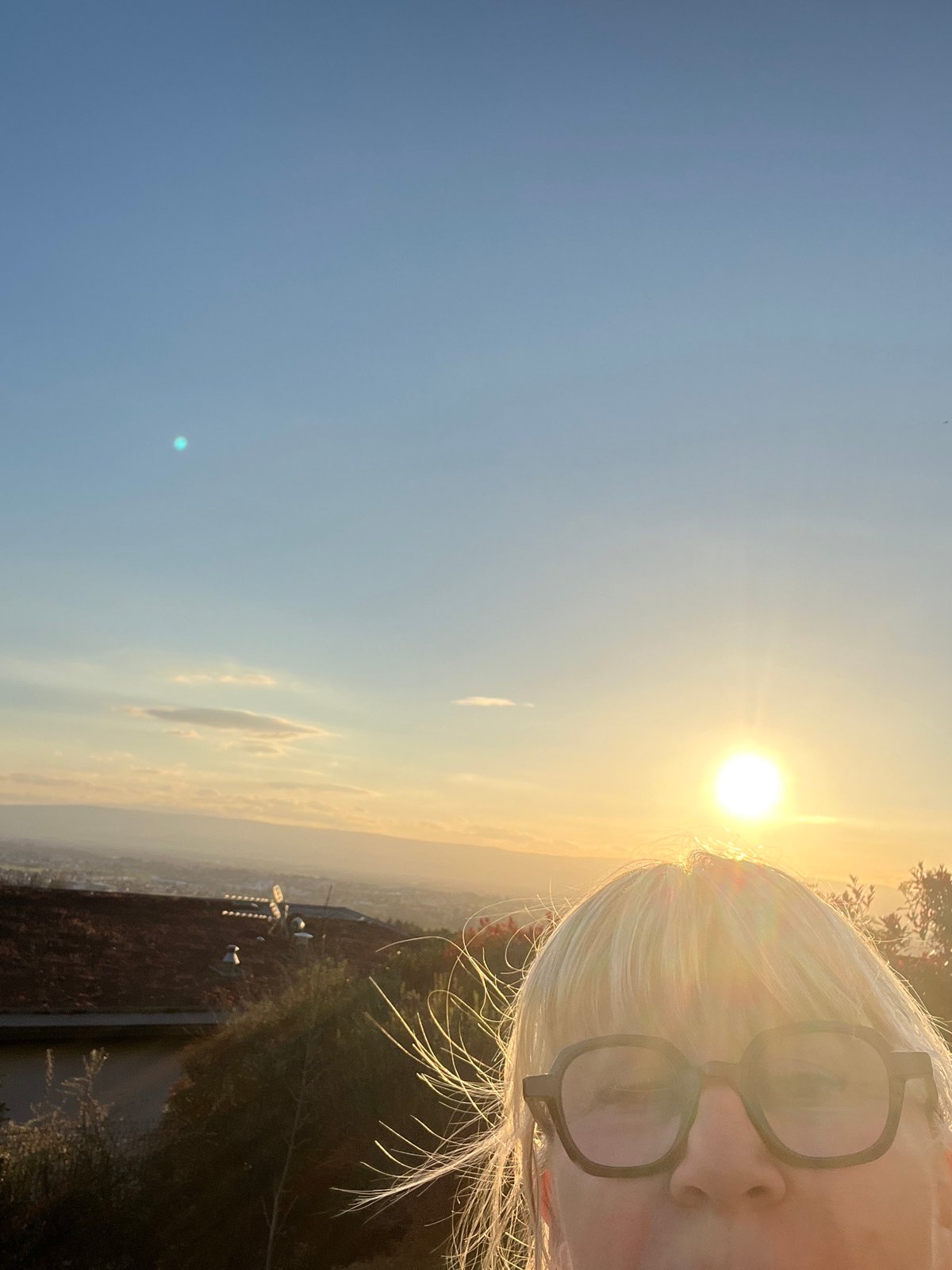 Woman takes multiple selfies in Chambœuf during sunset
