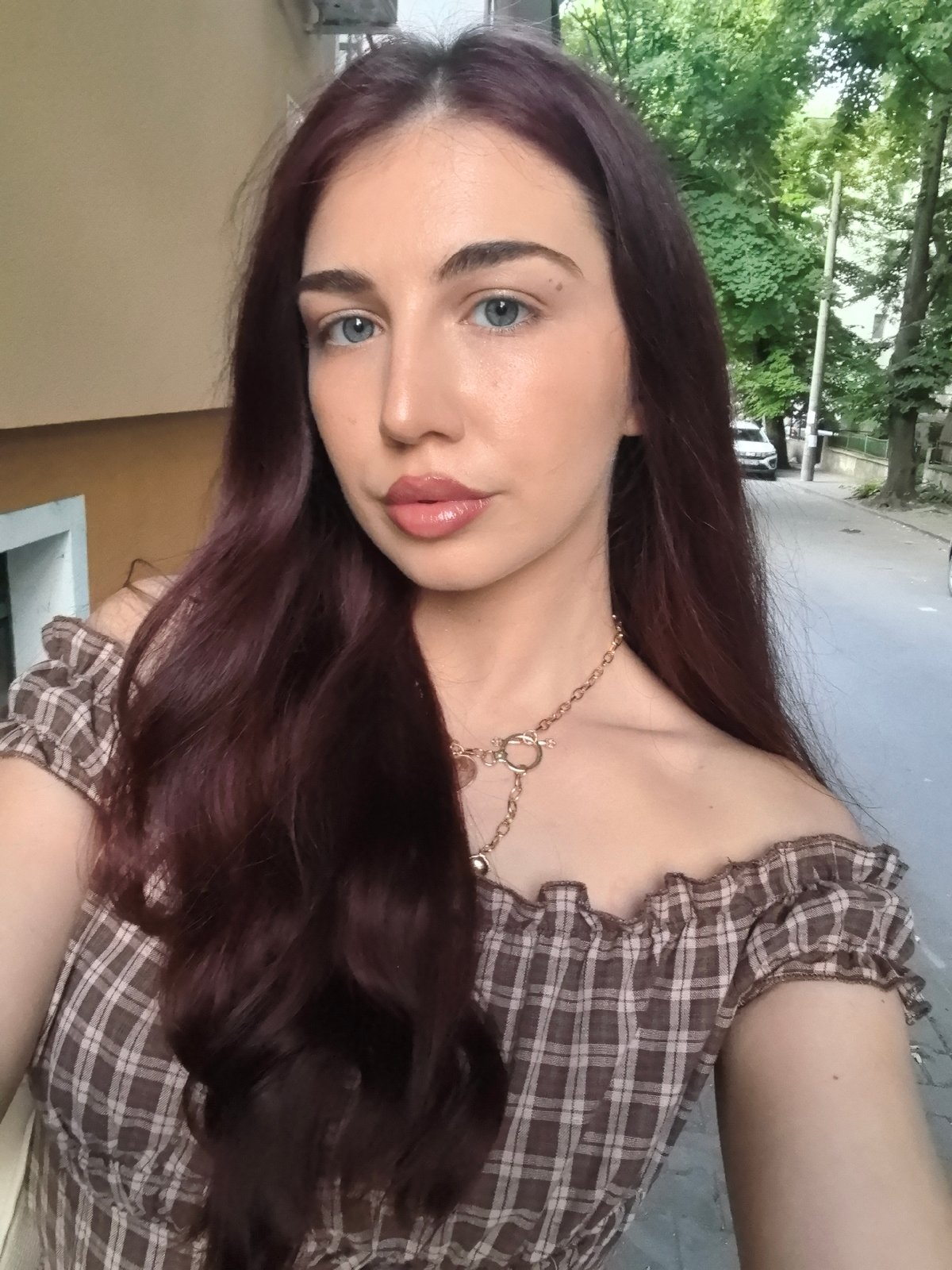 Woman in plaid dress photographed on Stara Zagora sidewalk