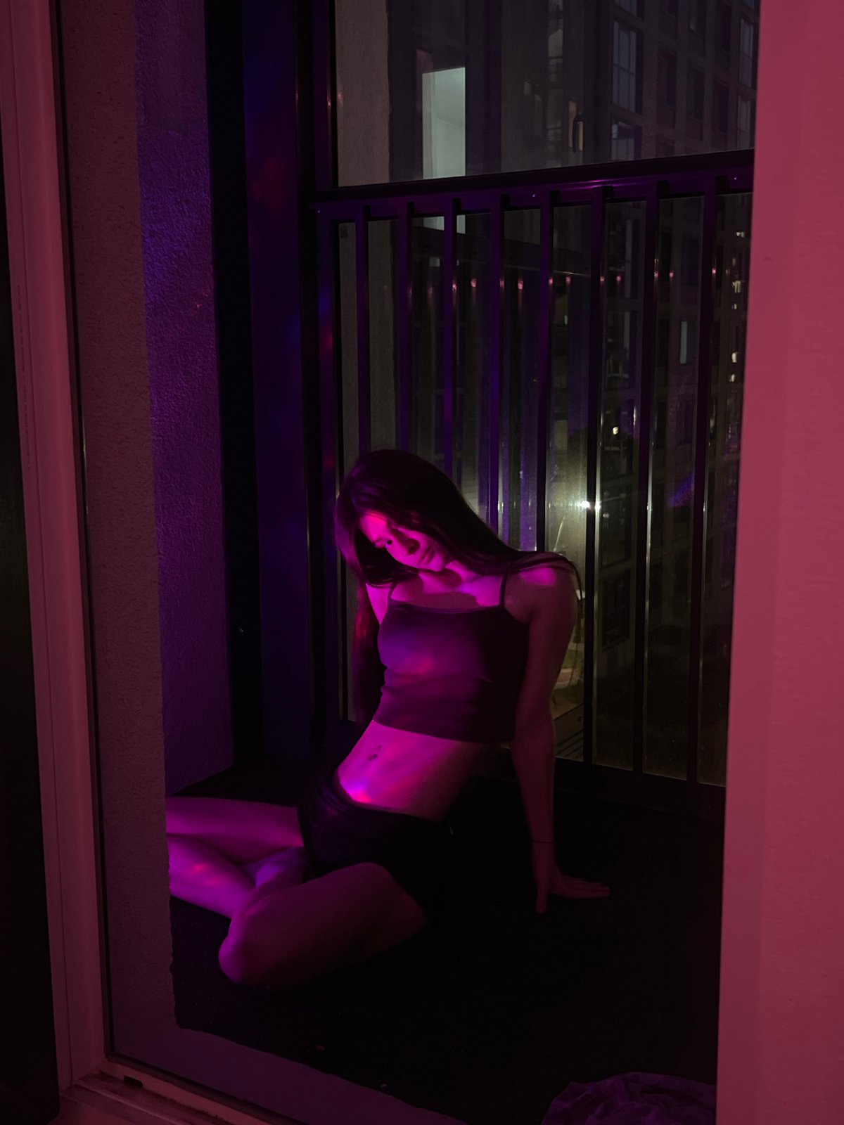 Evening balcony time at apartment complex with cat and city lights