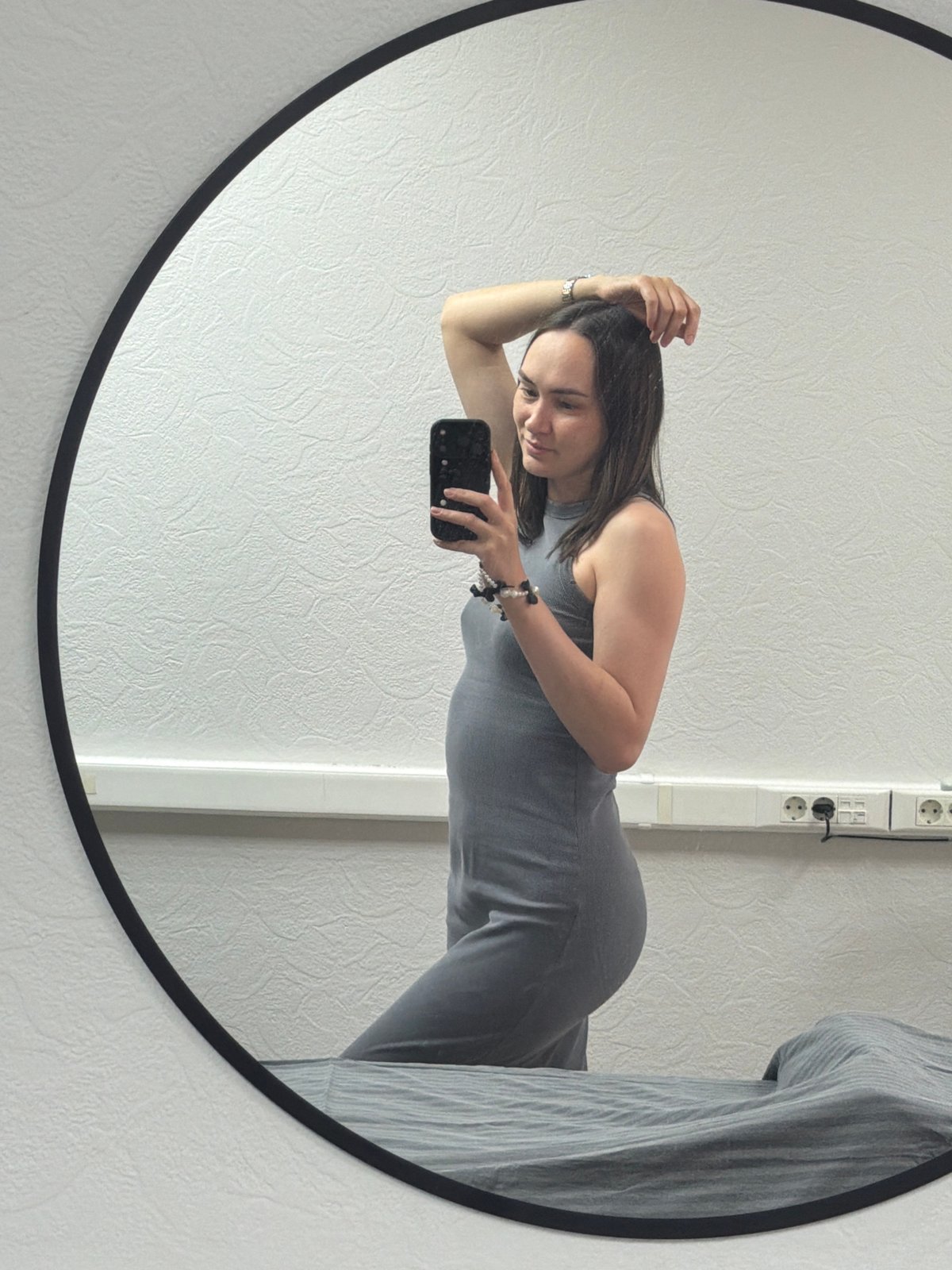 Woman takes mirror selfies in gray dress, Chaikovsky Russia