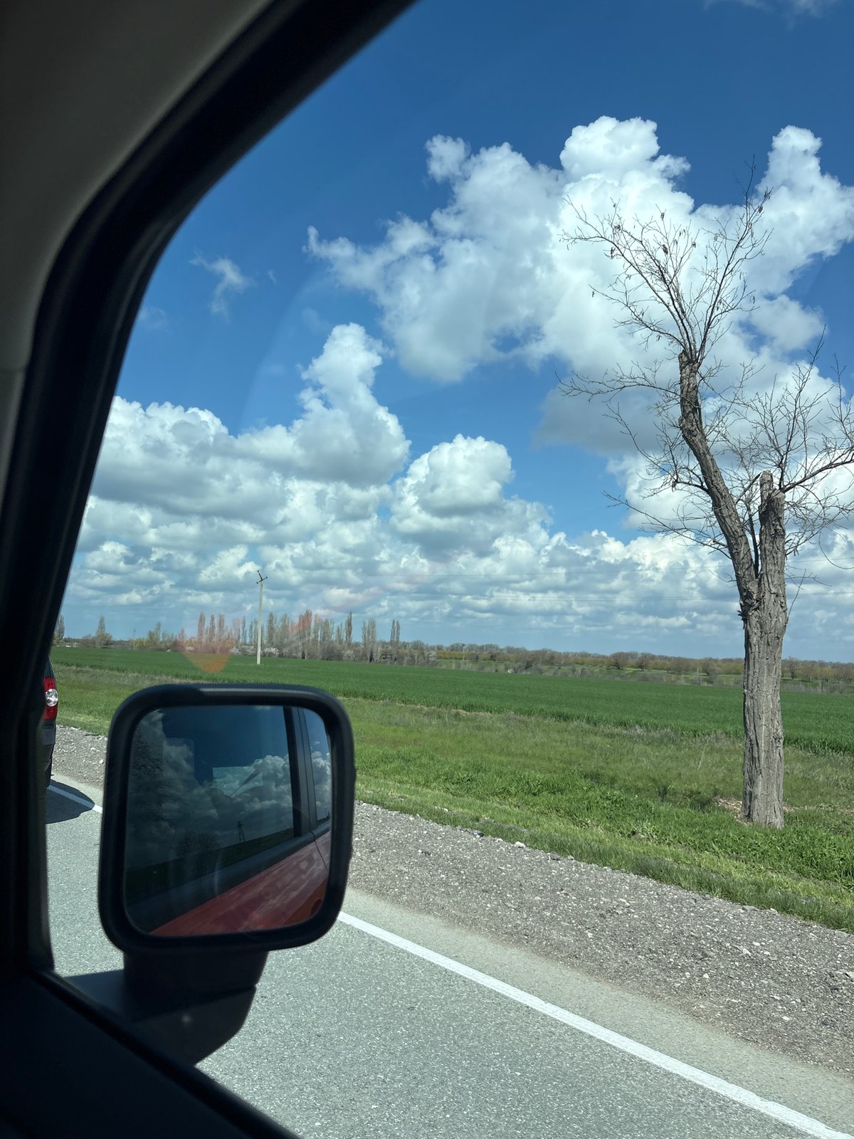 Vehicle travels through rural Ukrainian countryside under cloudy skies