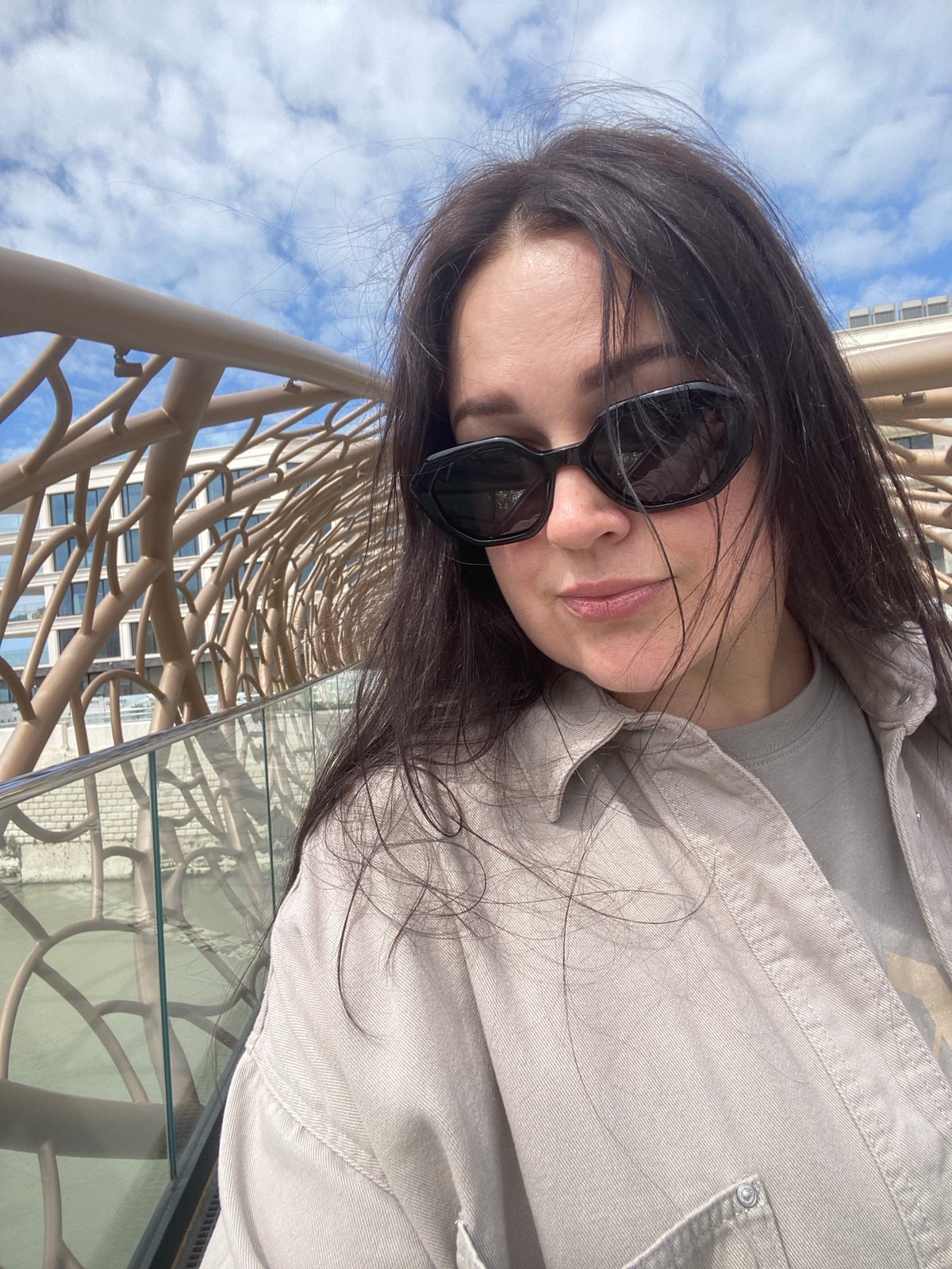 Woman photographs modern sculptural bridge in Sochi waterfront area