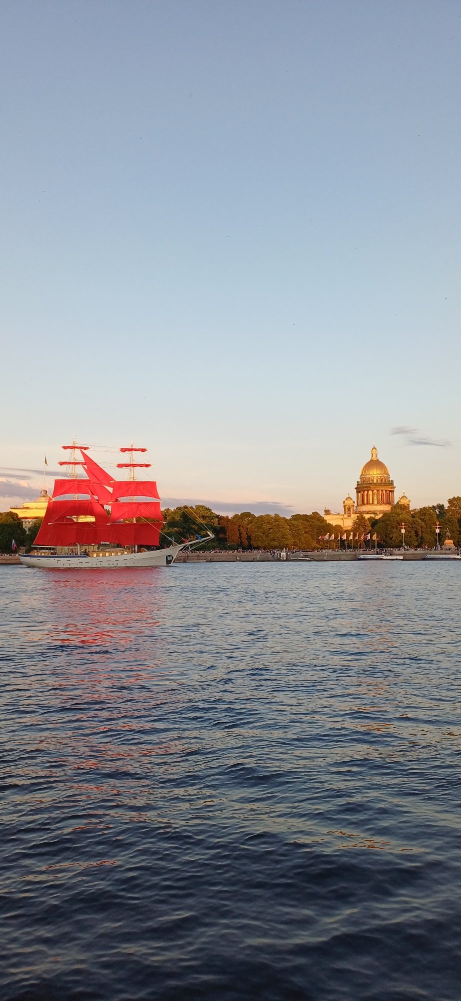 Red-sailed ship draws crowds during sunset passage through Saint Petersburg