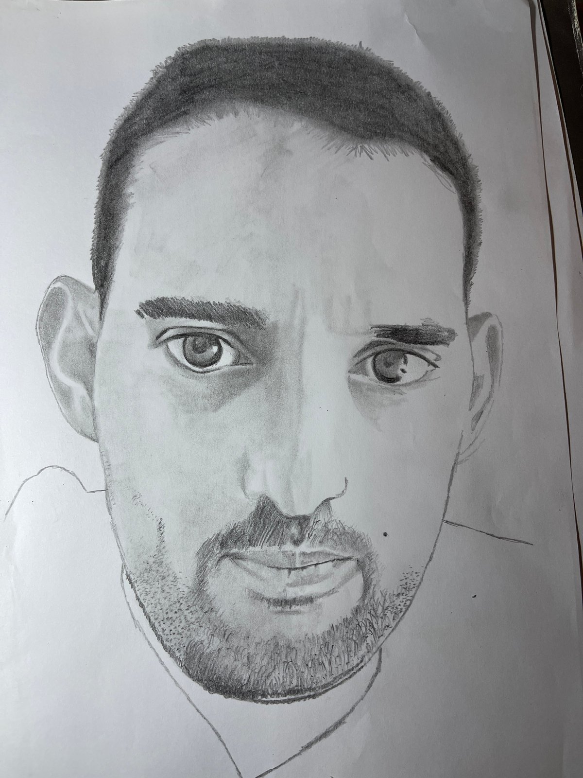 Artist sketches portrait from laptop reference photo in Jos