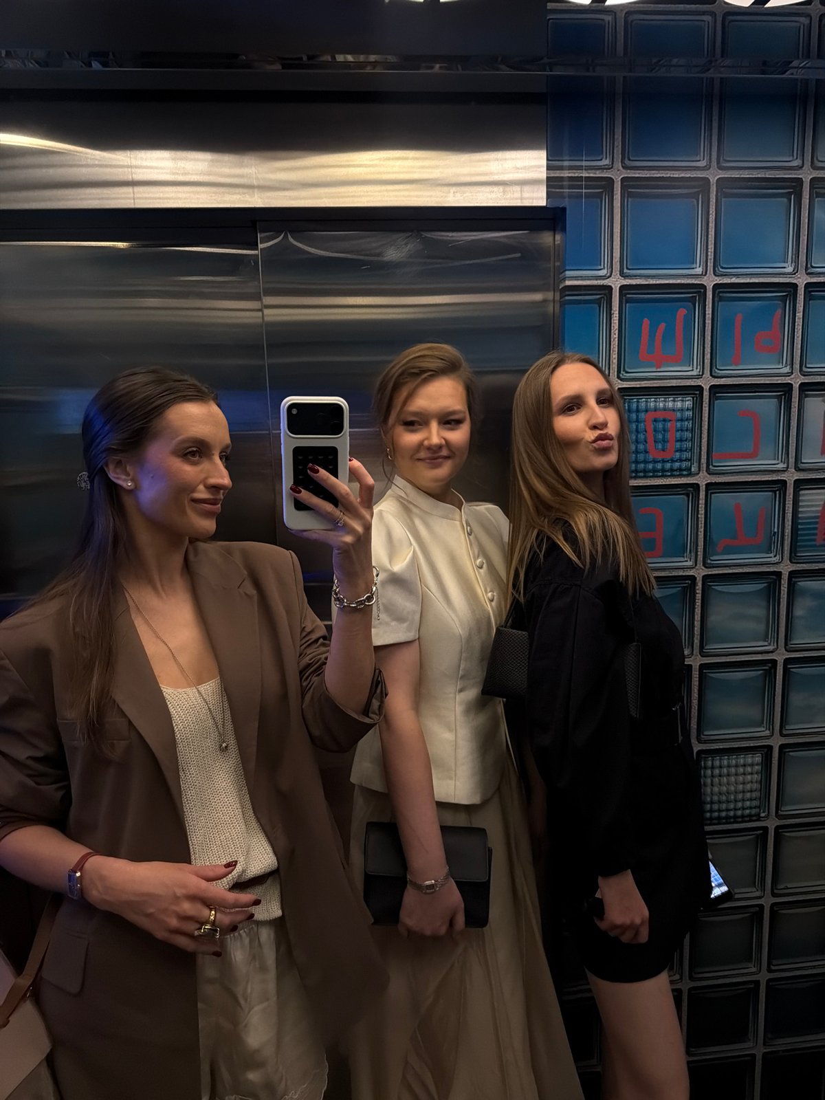 Women take selfies with flowers in Moscow elevator