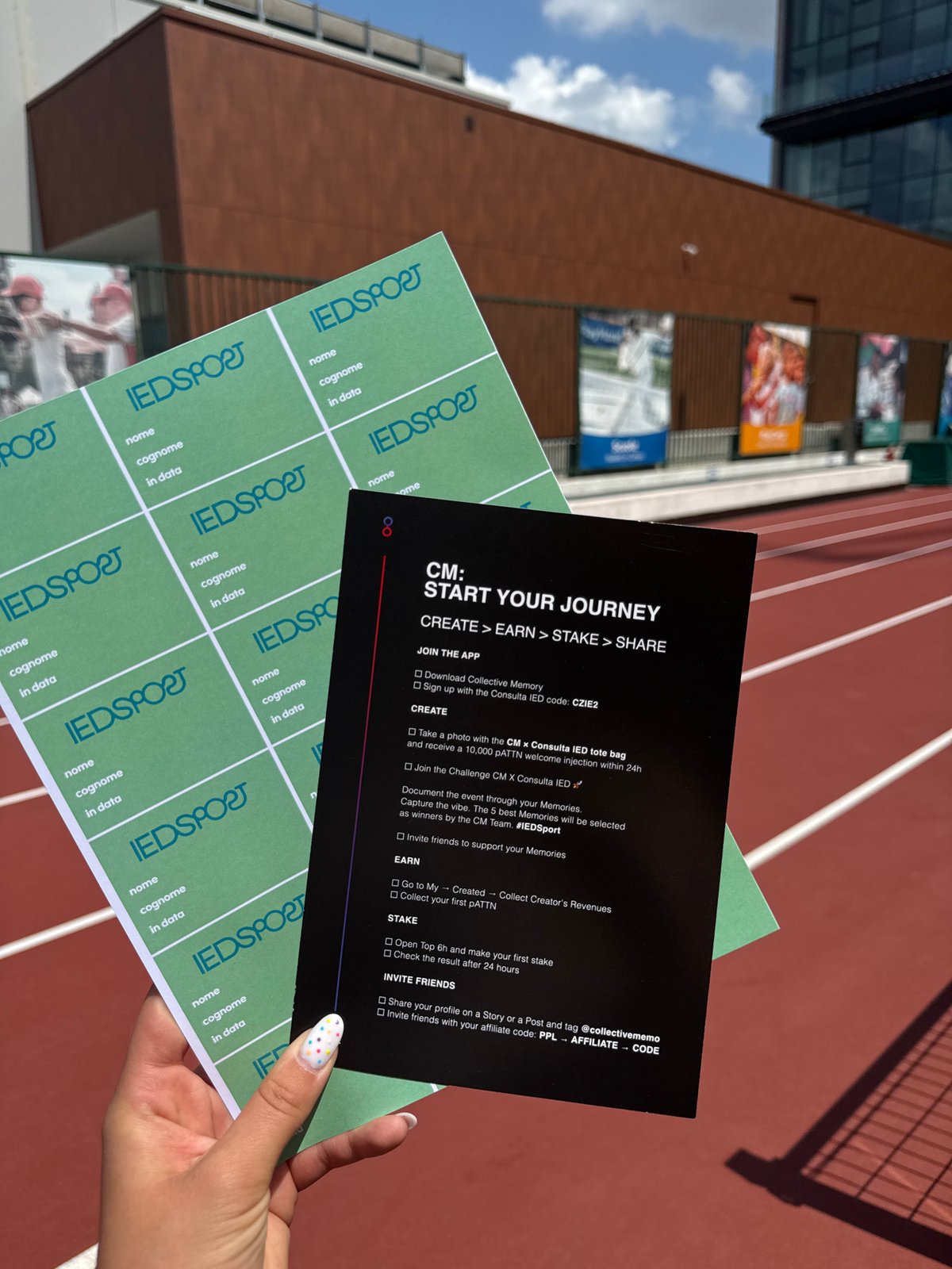 Person holds documents over Milan running track with decorated nails
