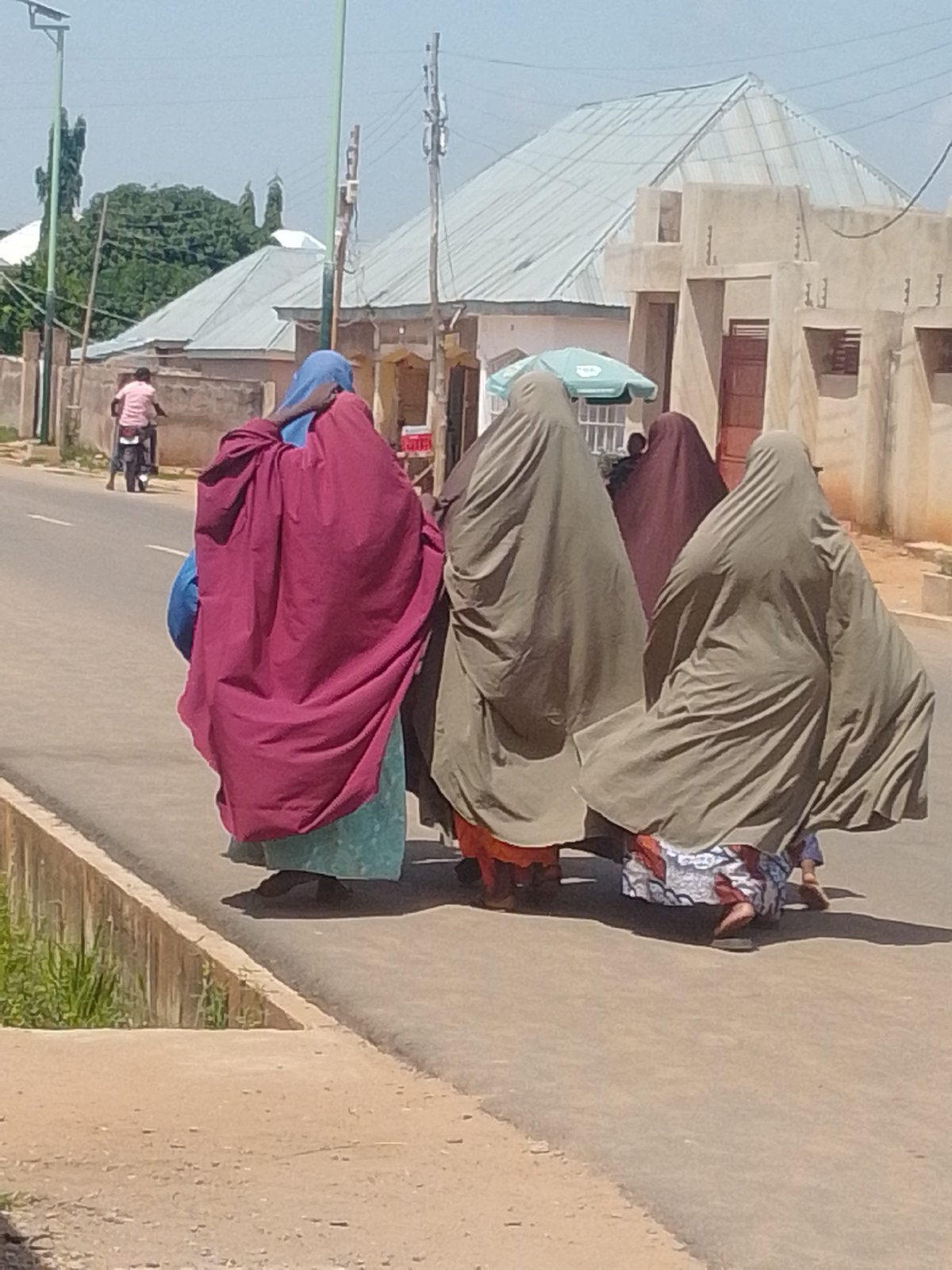 Group in traditional dress moves through urban streets