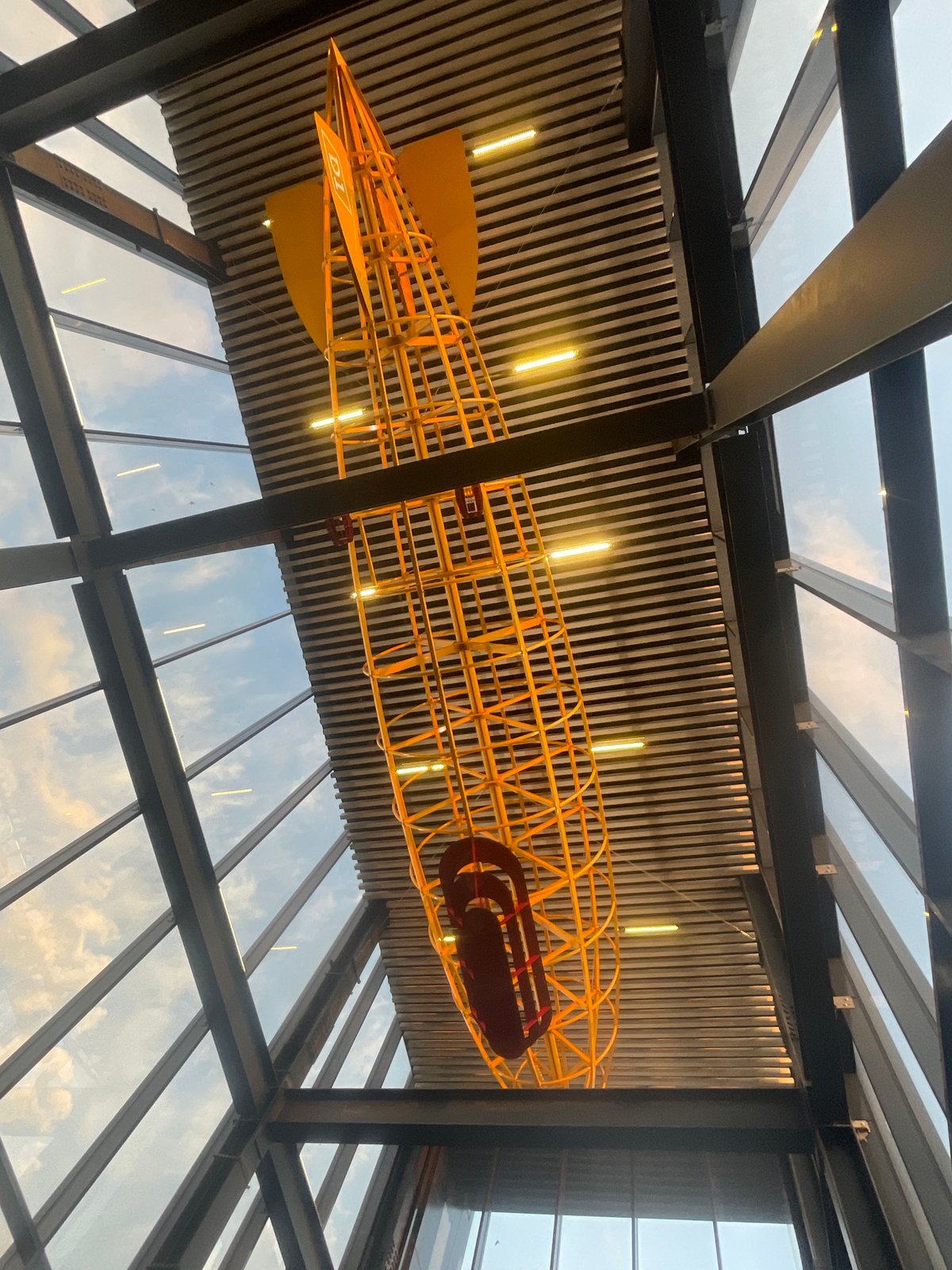 Yellow skeletal airship model displayed in modern building ceiling