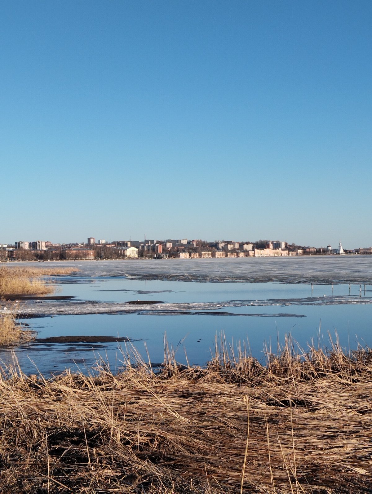 Clear skies over Votkinsk waterfront amid dry spring vegetation