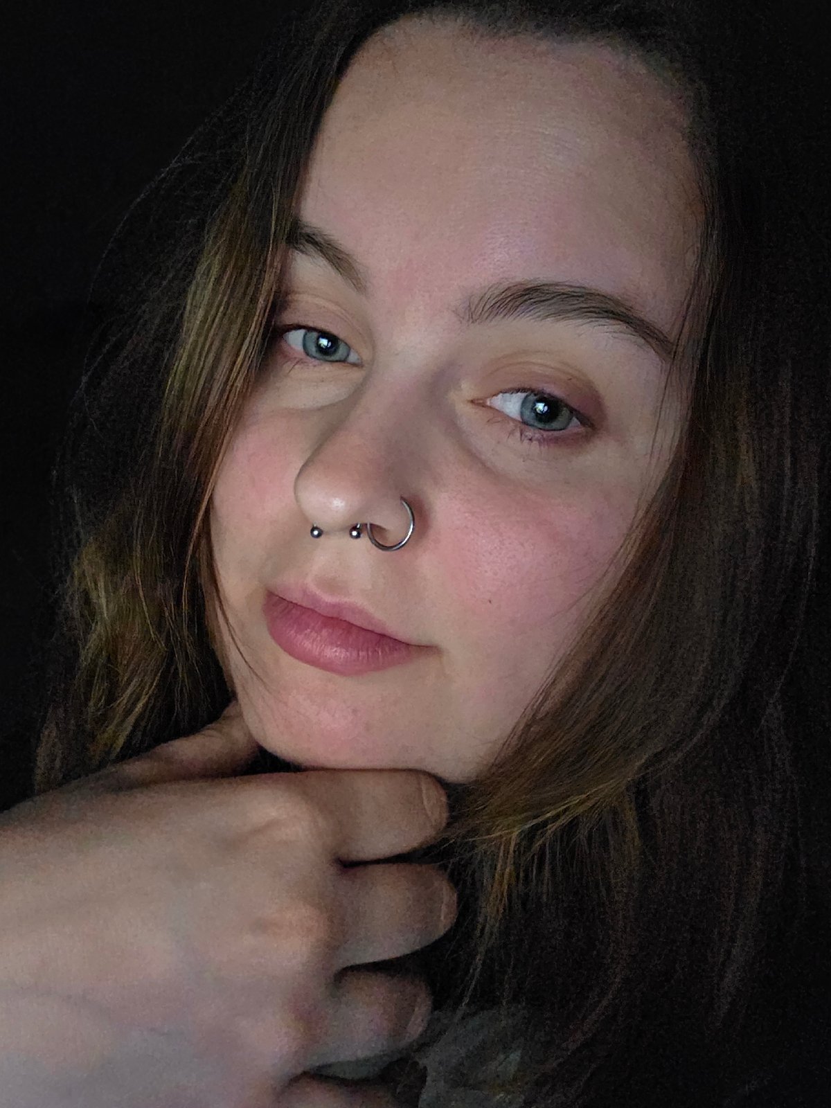 Portrait session captures woman with piercings, laptop keyboard documented