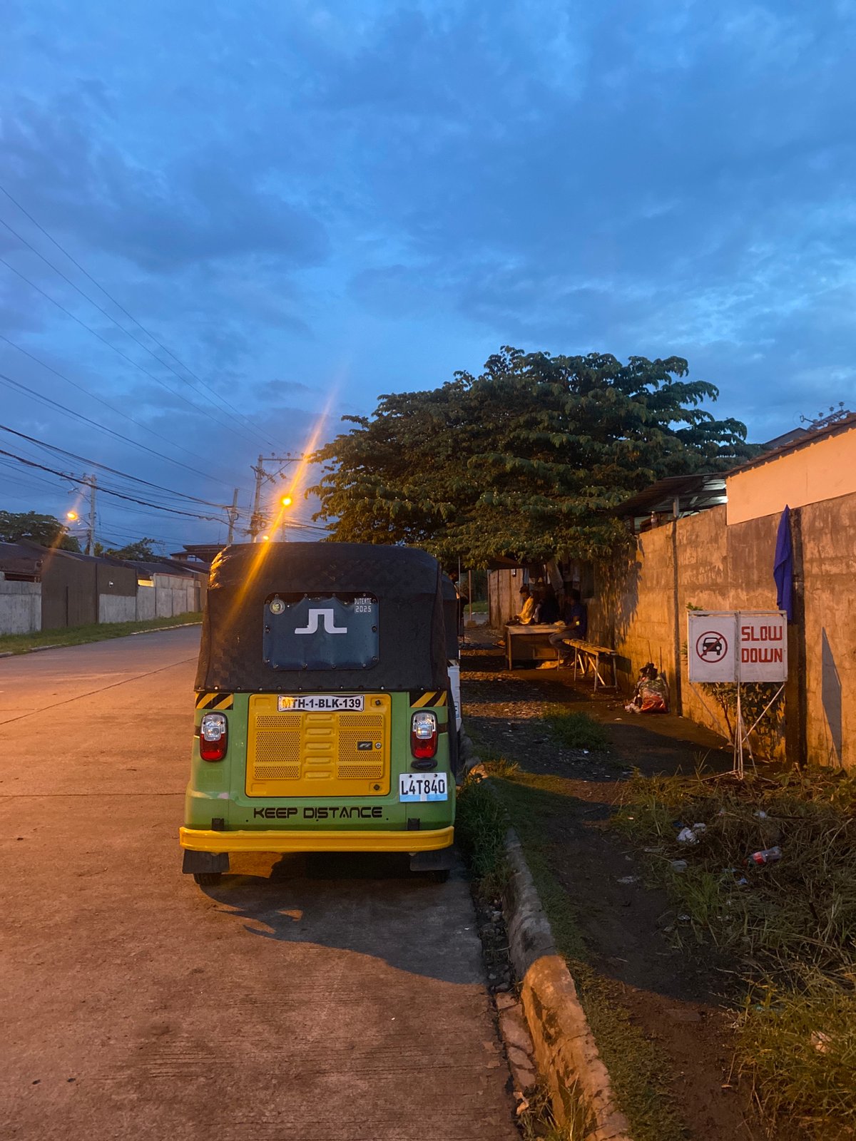 Davao City street at dusk, vehicles parked along a residential road