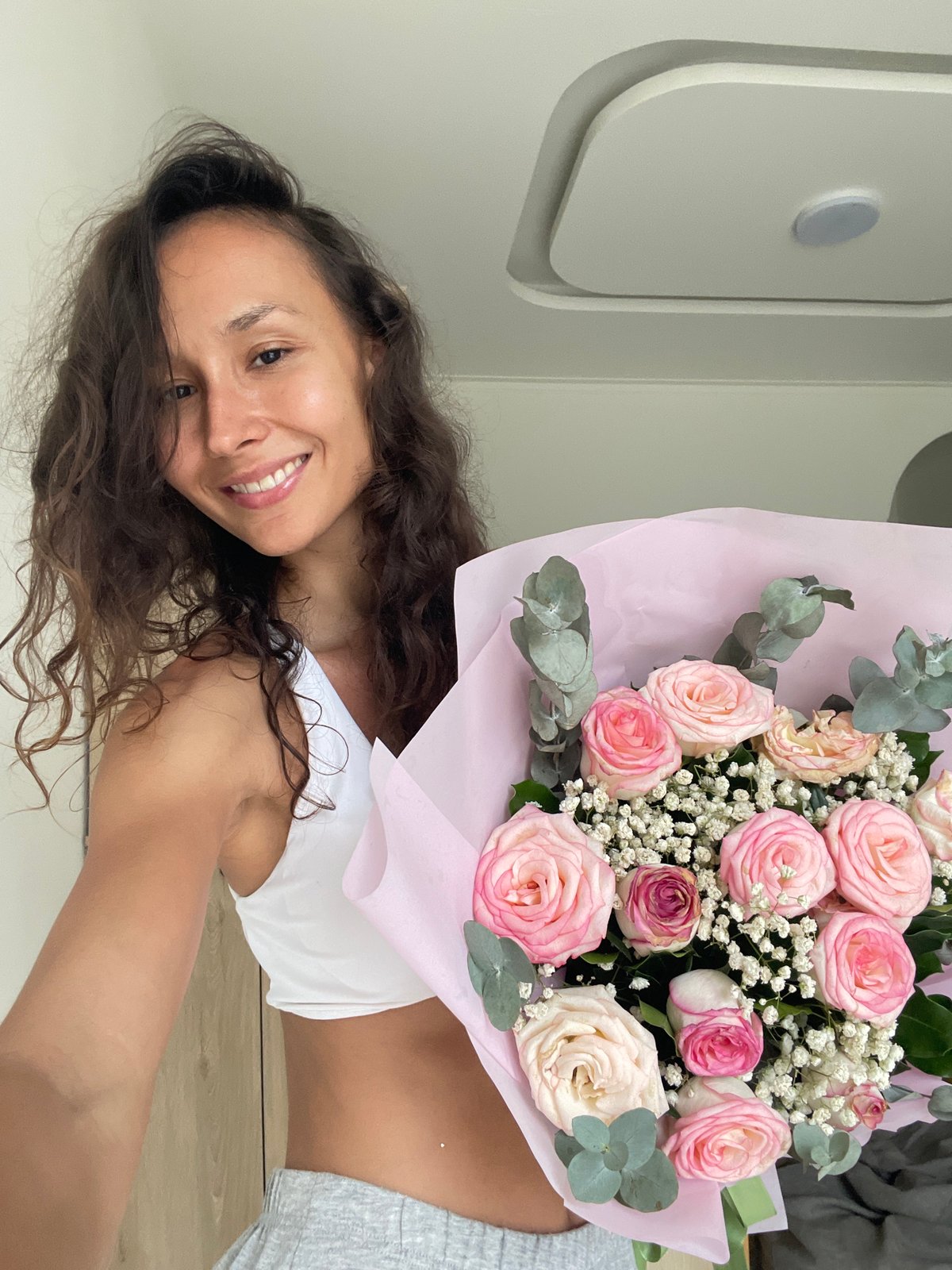 Woman poses with rose bouquet in Vietnamese photoshoot session