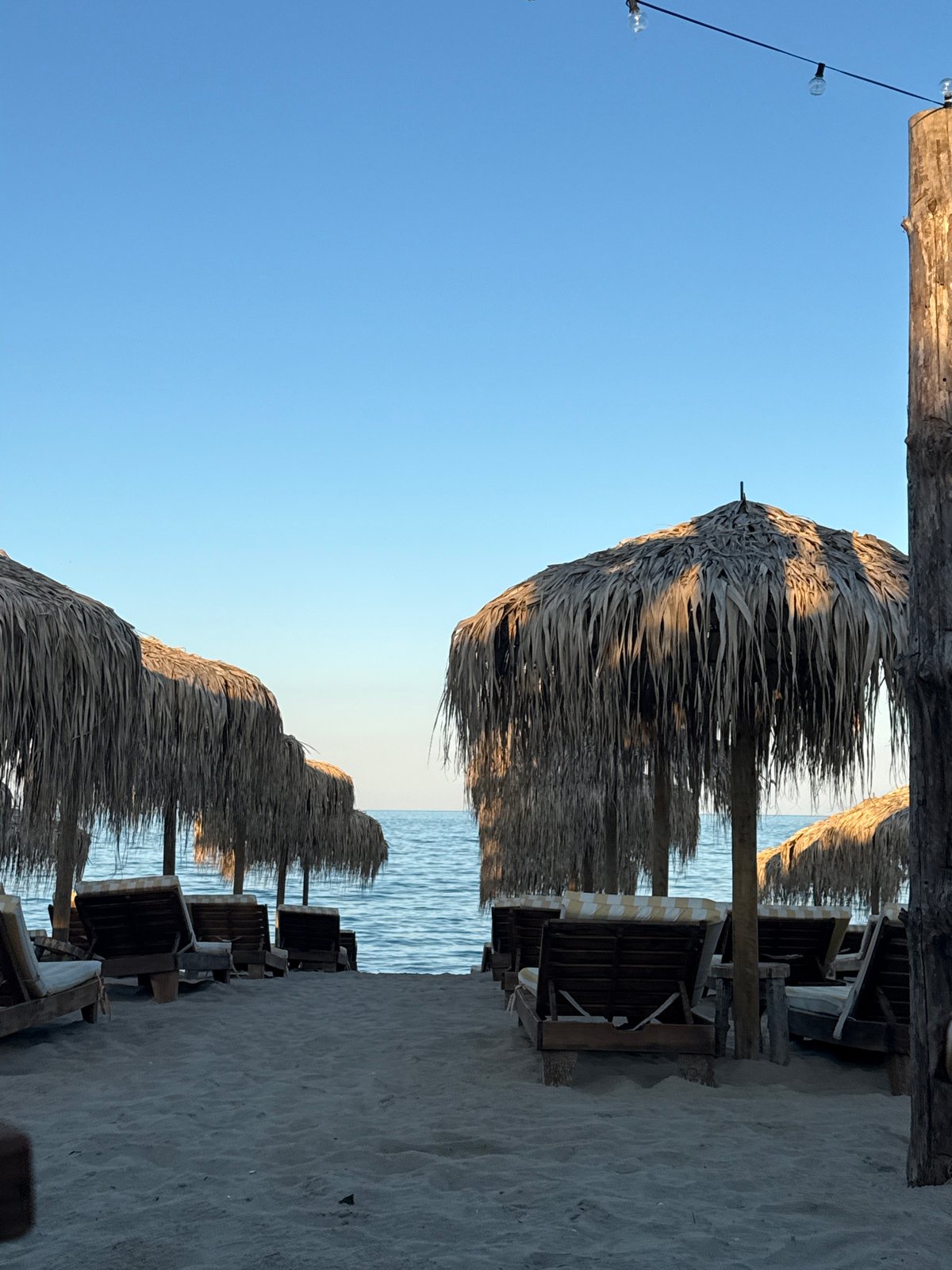 Empty beach chairs and wooden shade structures, Kranevo