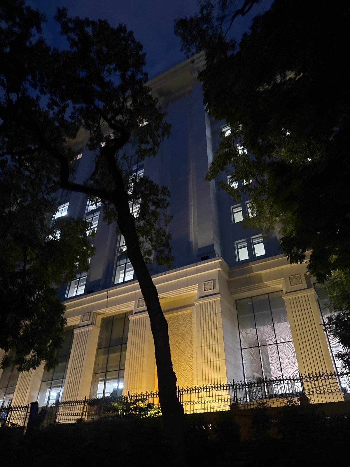 Hanoi park at dusk: ancient roots, stone paths, colonial backdrop