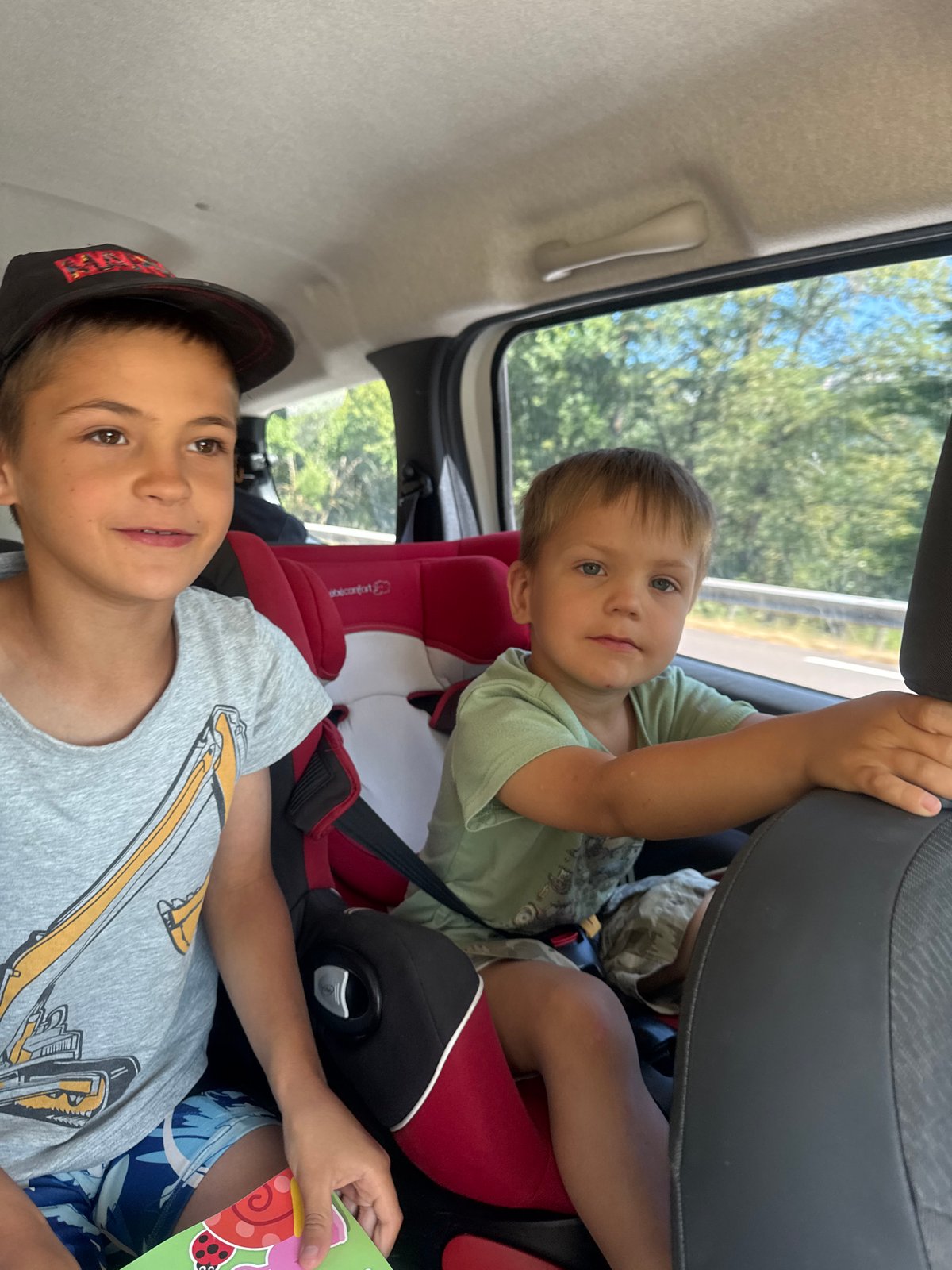 Kids in the back seat on a road trip through rural France