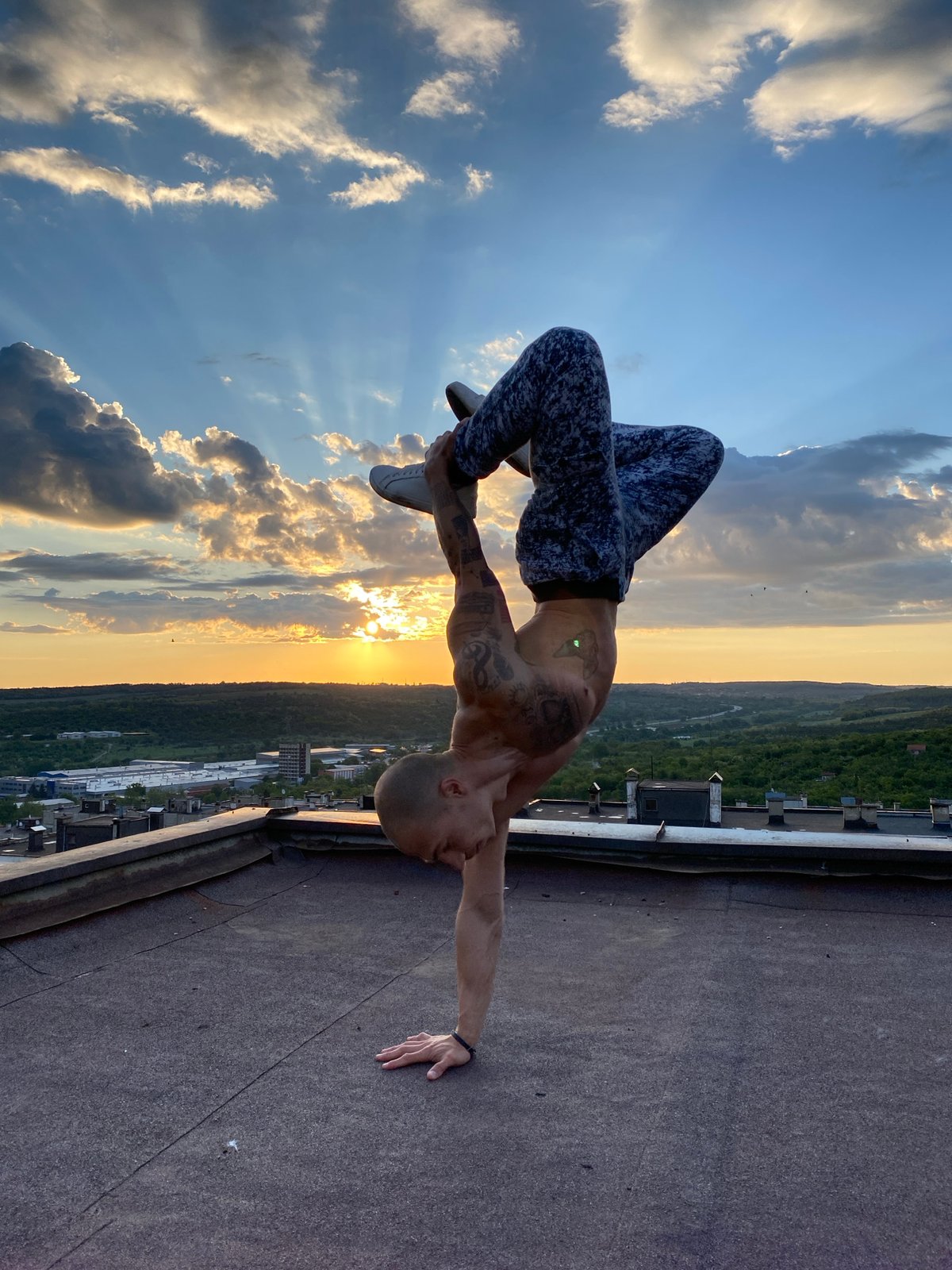 Man performs rooftop handstands during sunset in Pleven, Bulgaria