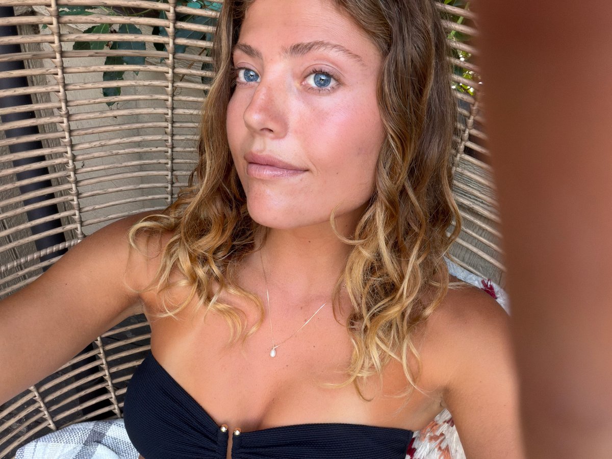 Woman relaxes outdoors in wicker chair in Malibu