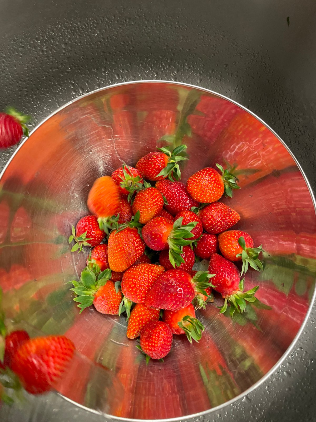 Bowl of fresh strawberries observed on wet surface in Montenegro