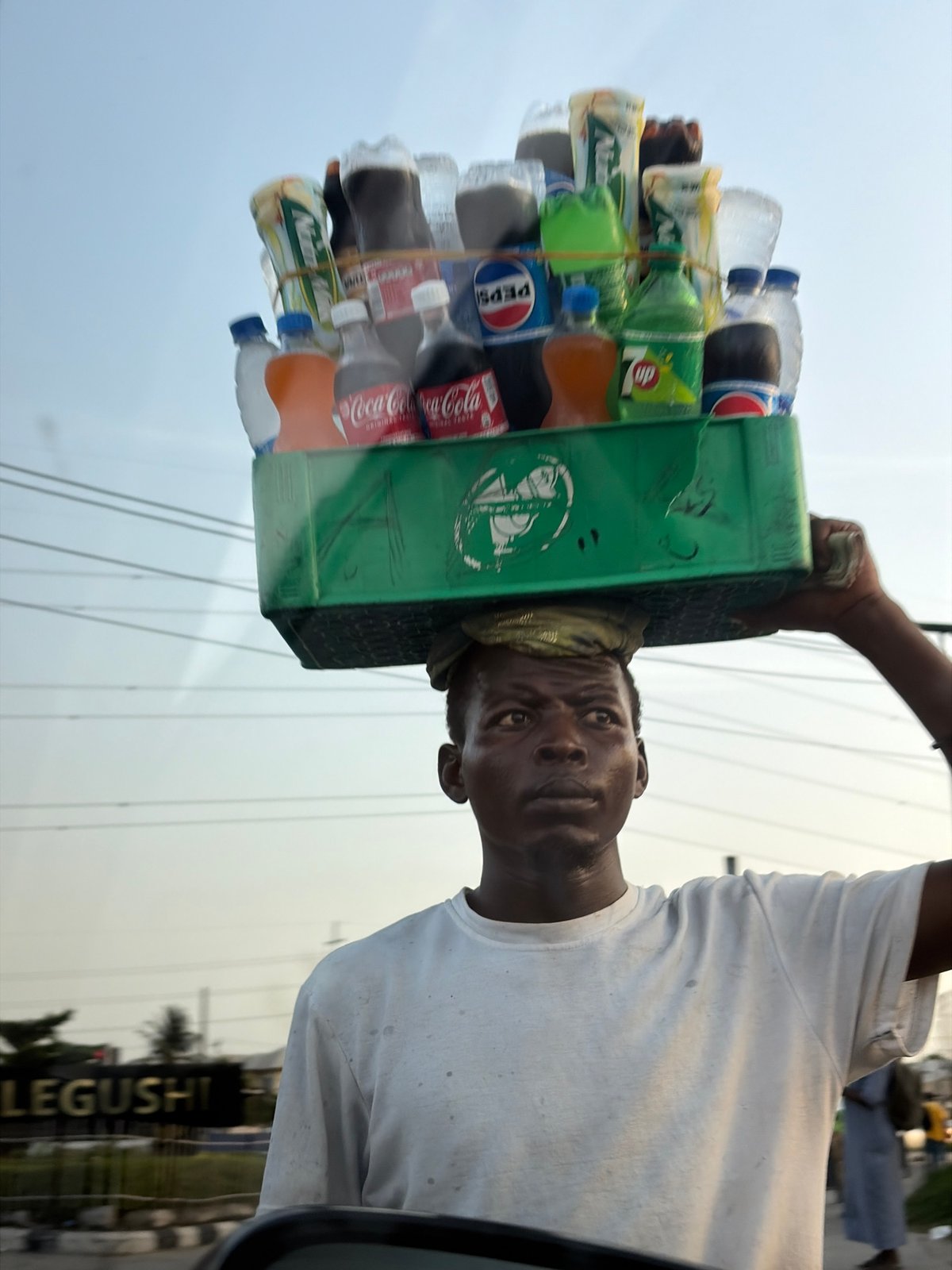 Vendor carries soft drinks on head in Alaguntan, Nigeria