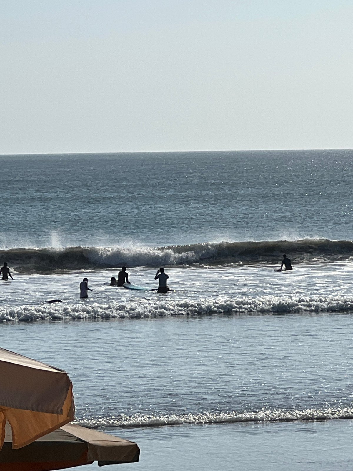 Busy morning at Kuta Beach with surfers and beachgoers
