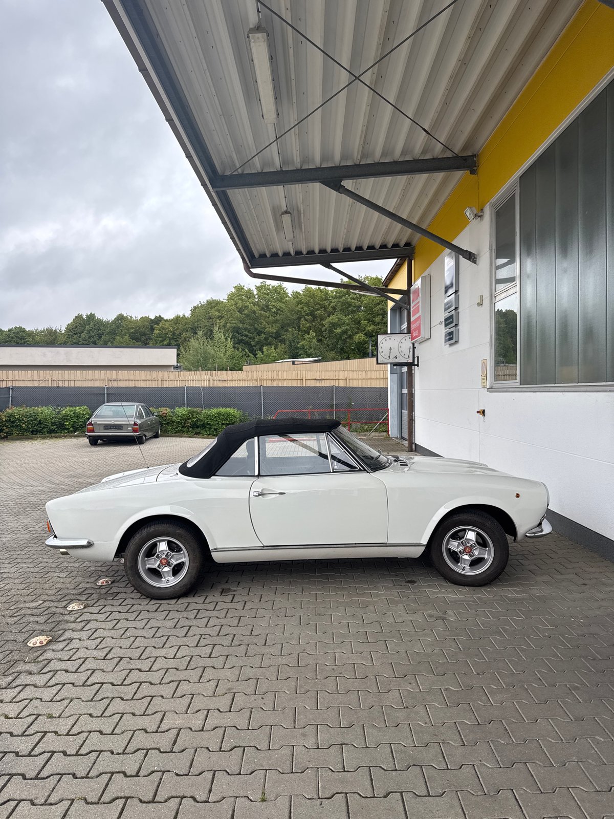 White Fiat 124 Spider parked under awning in Wettstetten