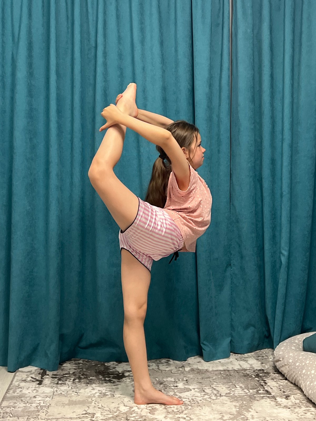 Young gymnast practices acrobatic moves at home in Chaikovsky