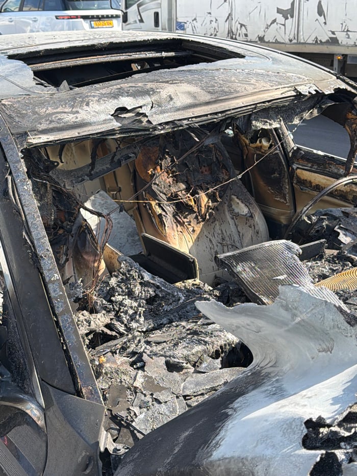 Fire-damaged car and sleeping cat observed in Holon