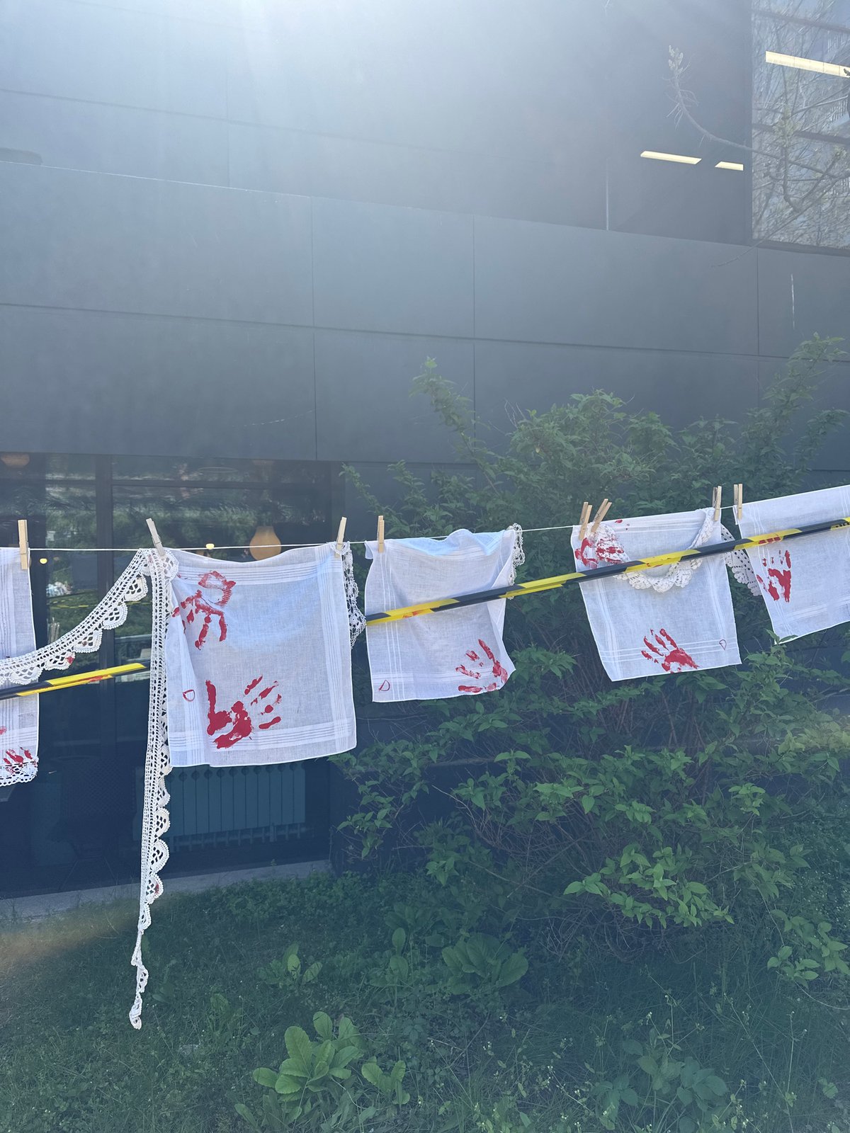 Handprint-decorated handkerchiefs displayed on pole in Sofia