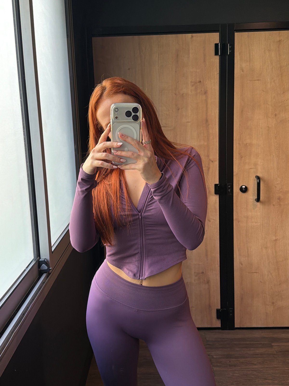 Woman takes selfie in purple athletic wear in Paris dressing room