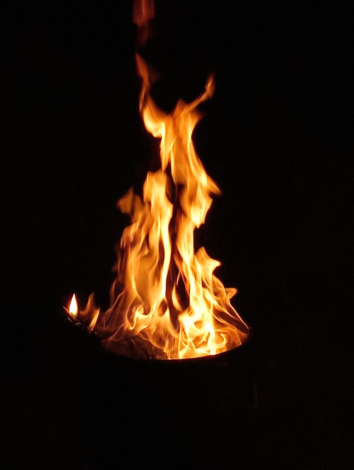 Metal barrel fire burning at night in Shymkent