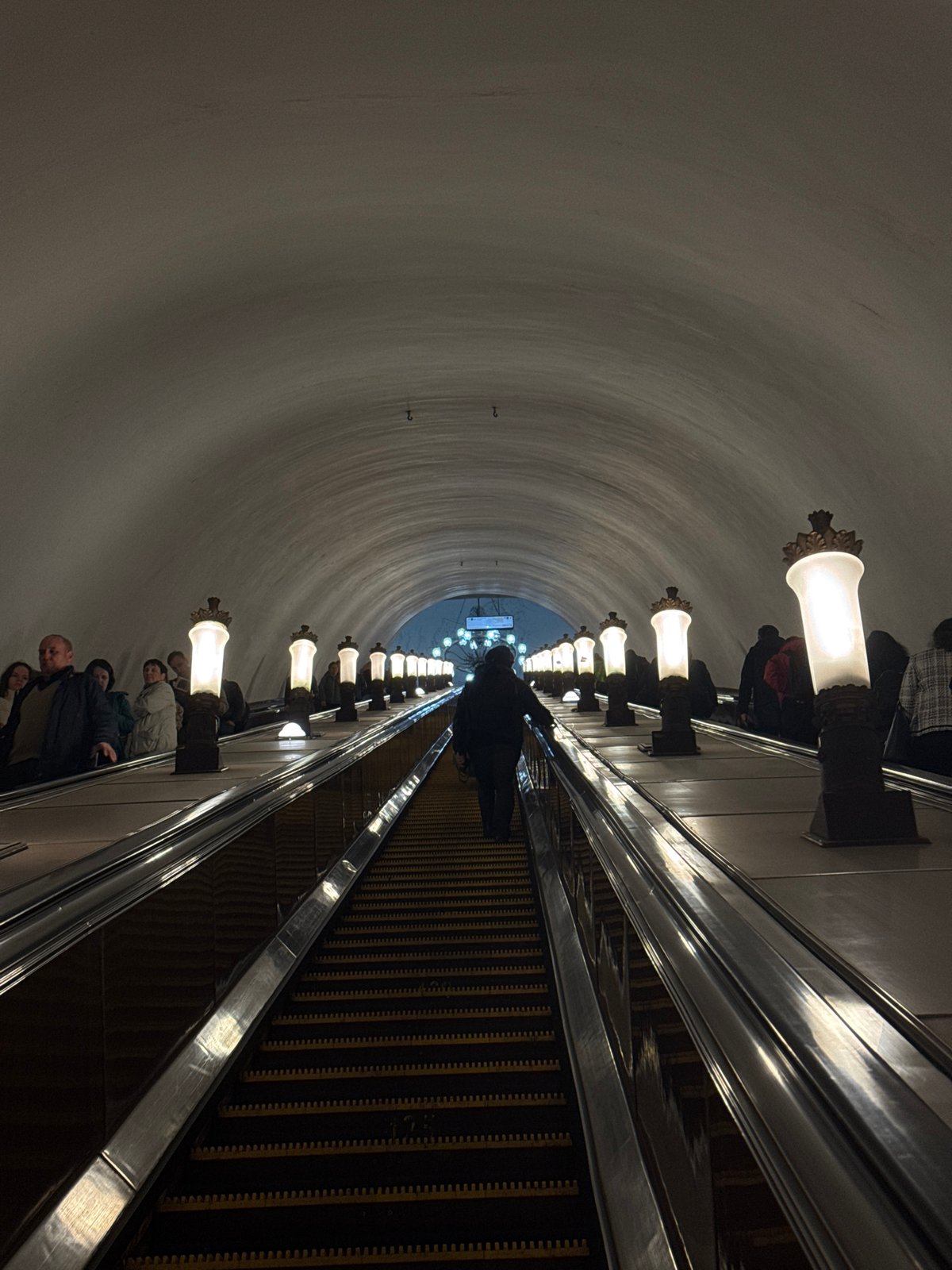 Moscow metro station captured with escalator passengers, star mosaic