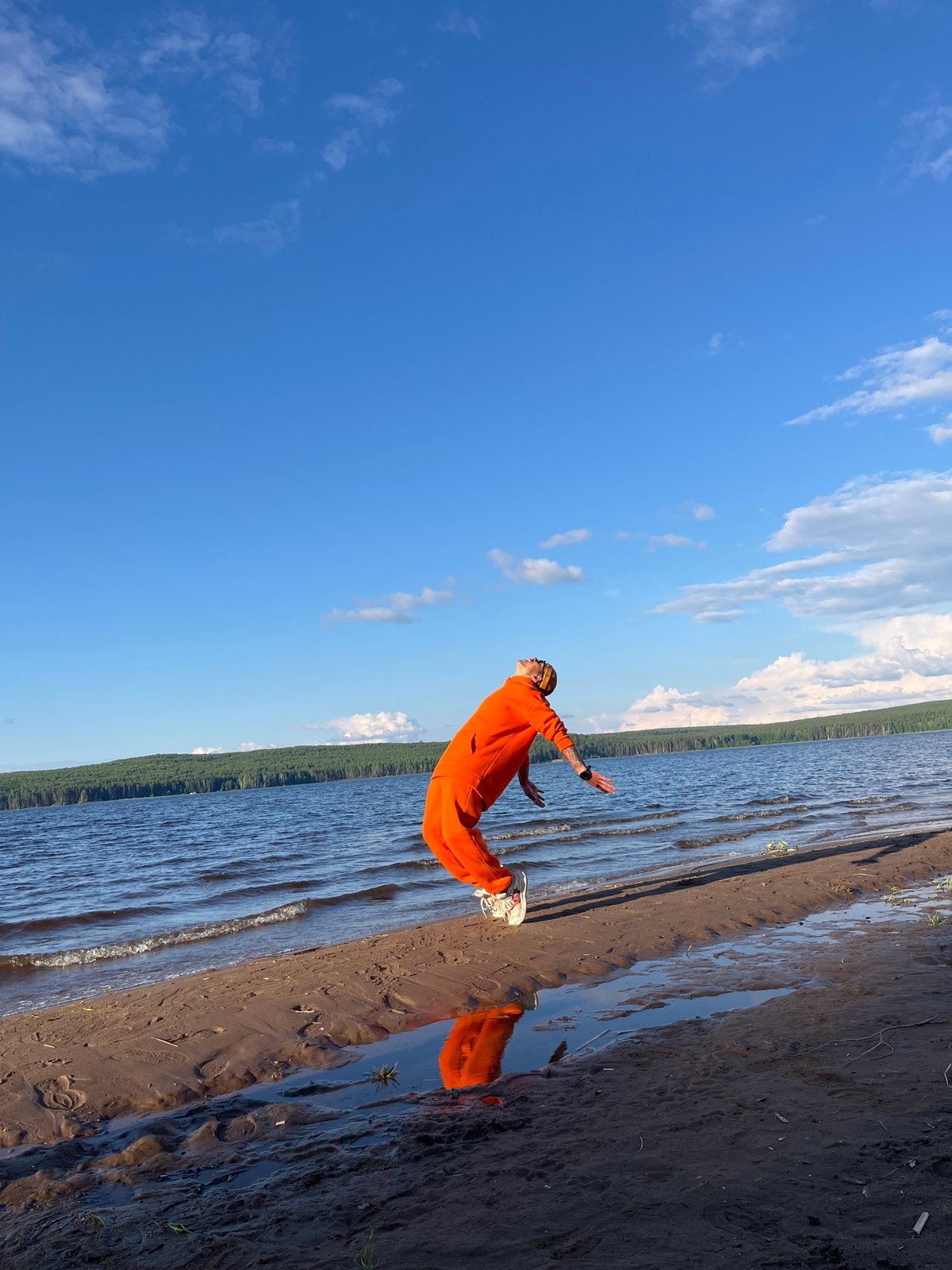 Person jumps on shore creating water reflection in Chaikovsky