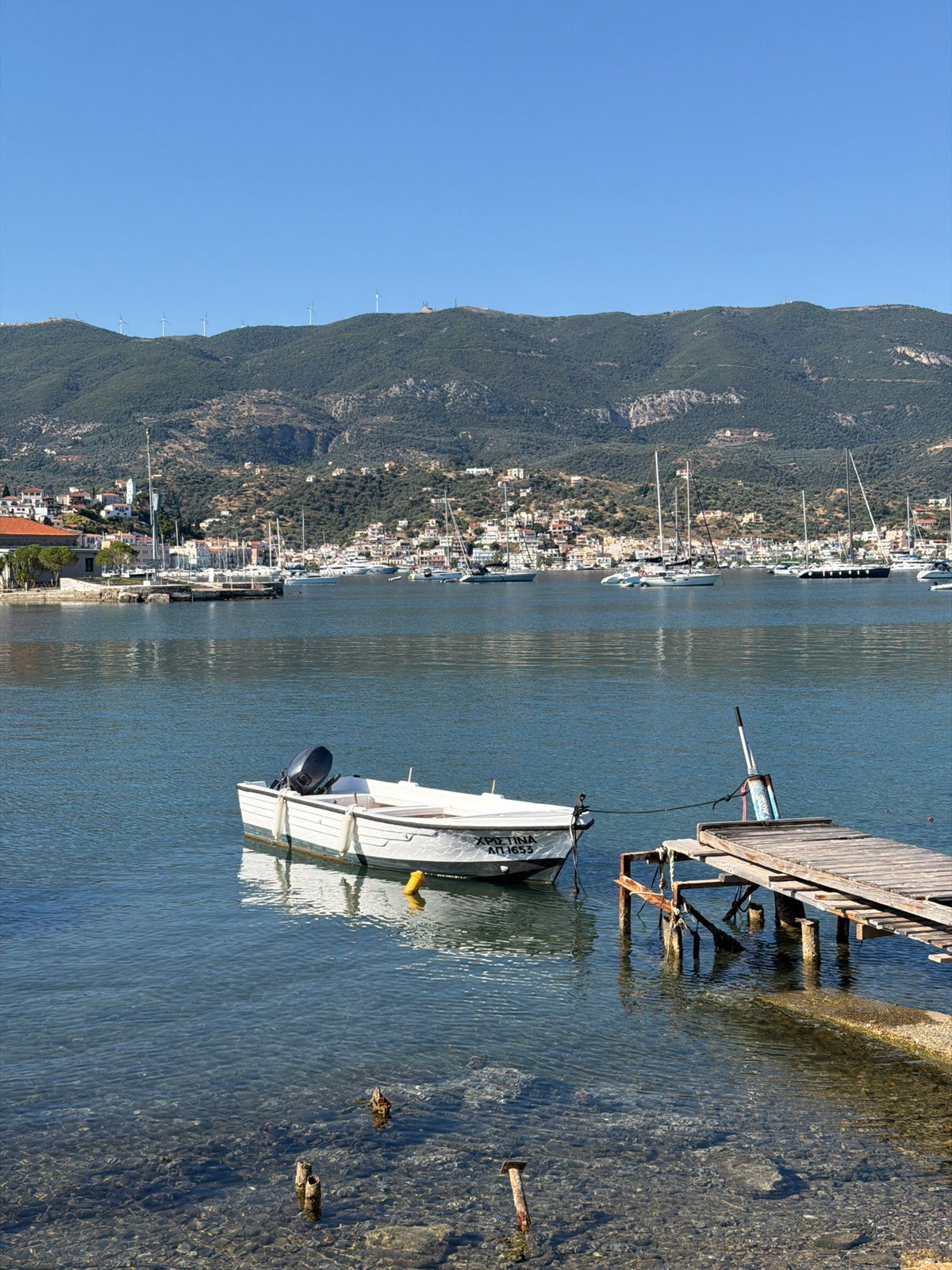 Artist sketches flowers, boats during morning in Poros harbor