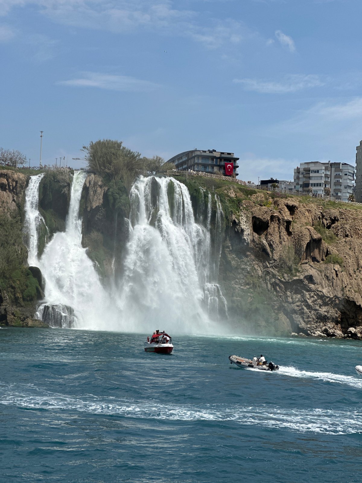 Tourist documents Düden Waterfall cascading into Mediterranean from boat