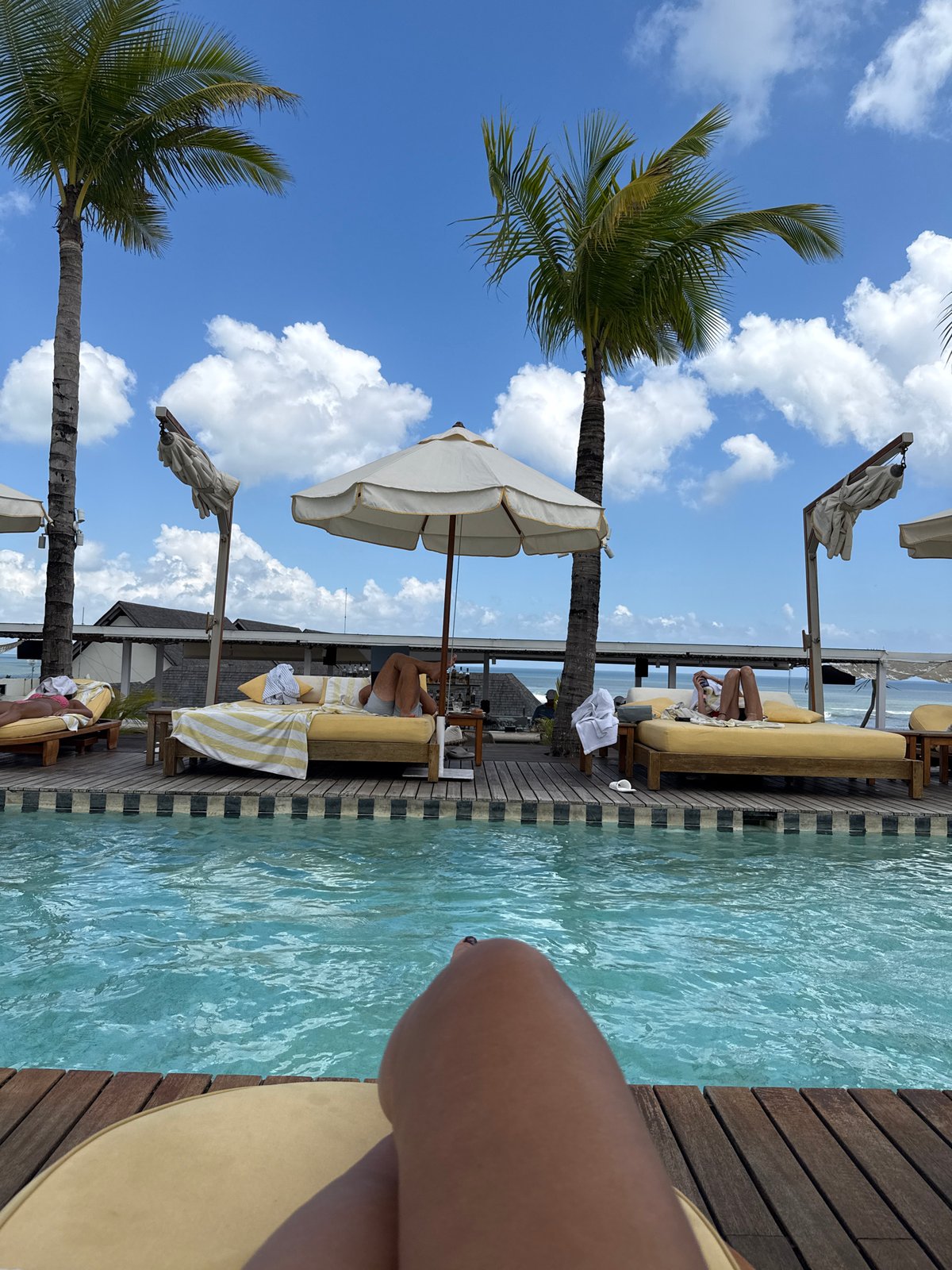 Tourist relaxes poolside at North Kuta resort early morning