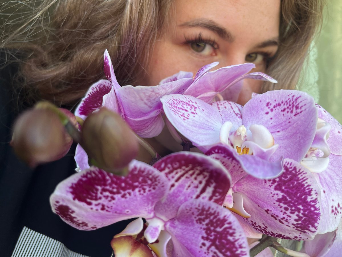 Woman photographs herself with orchids in Сосново, Russia