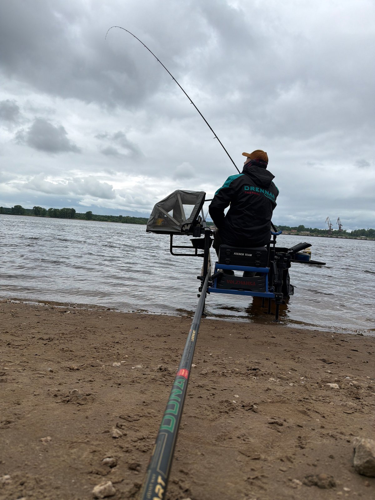 Angler fishes Kama River in overcast Chaikovsky morning