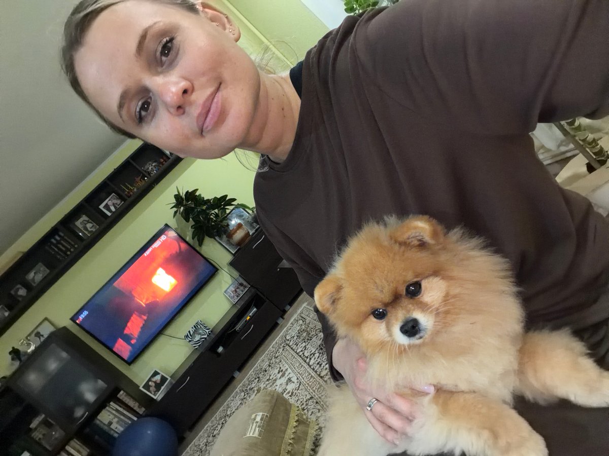Woman holds Pomeranian dog at home in Sarapul, Russia