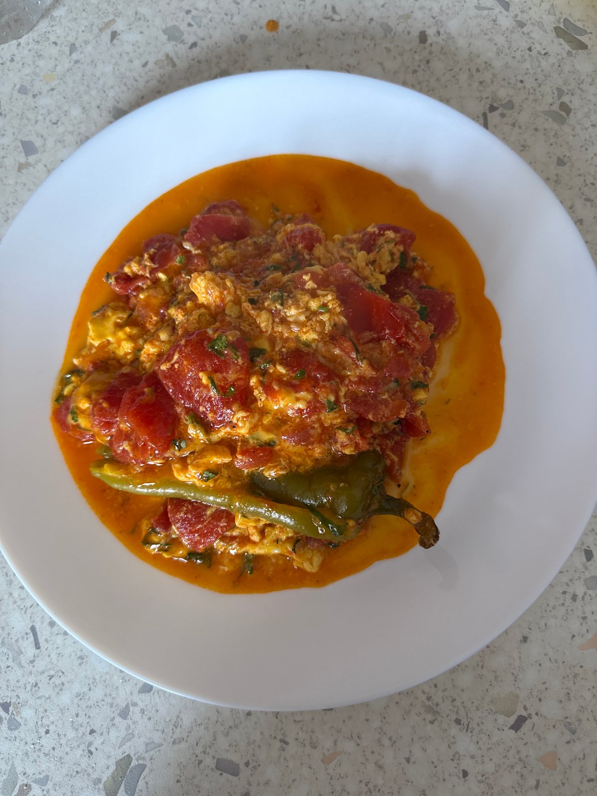 Scrambled eggs with tomatoes and peppers, cooked and plated in Milan