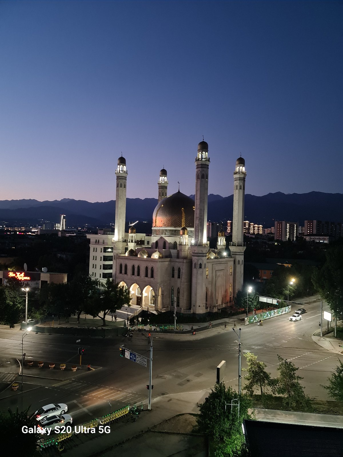 Almaty's Central Mosque glows at dusk against a colorful sky.