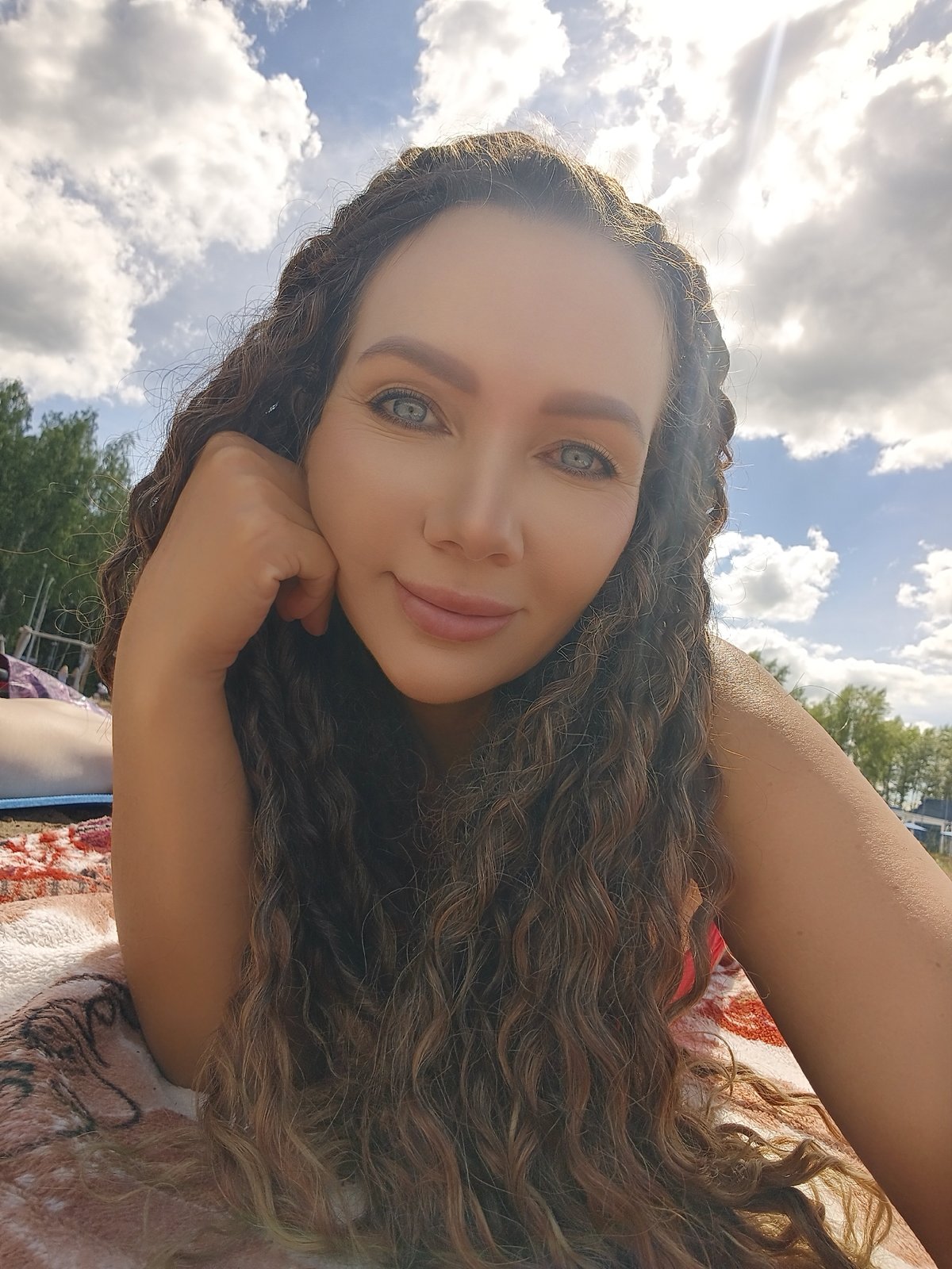 Sunny beach day: blanket lounging, selfies, and shoreline views