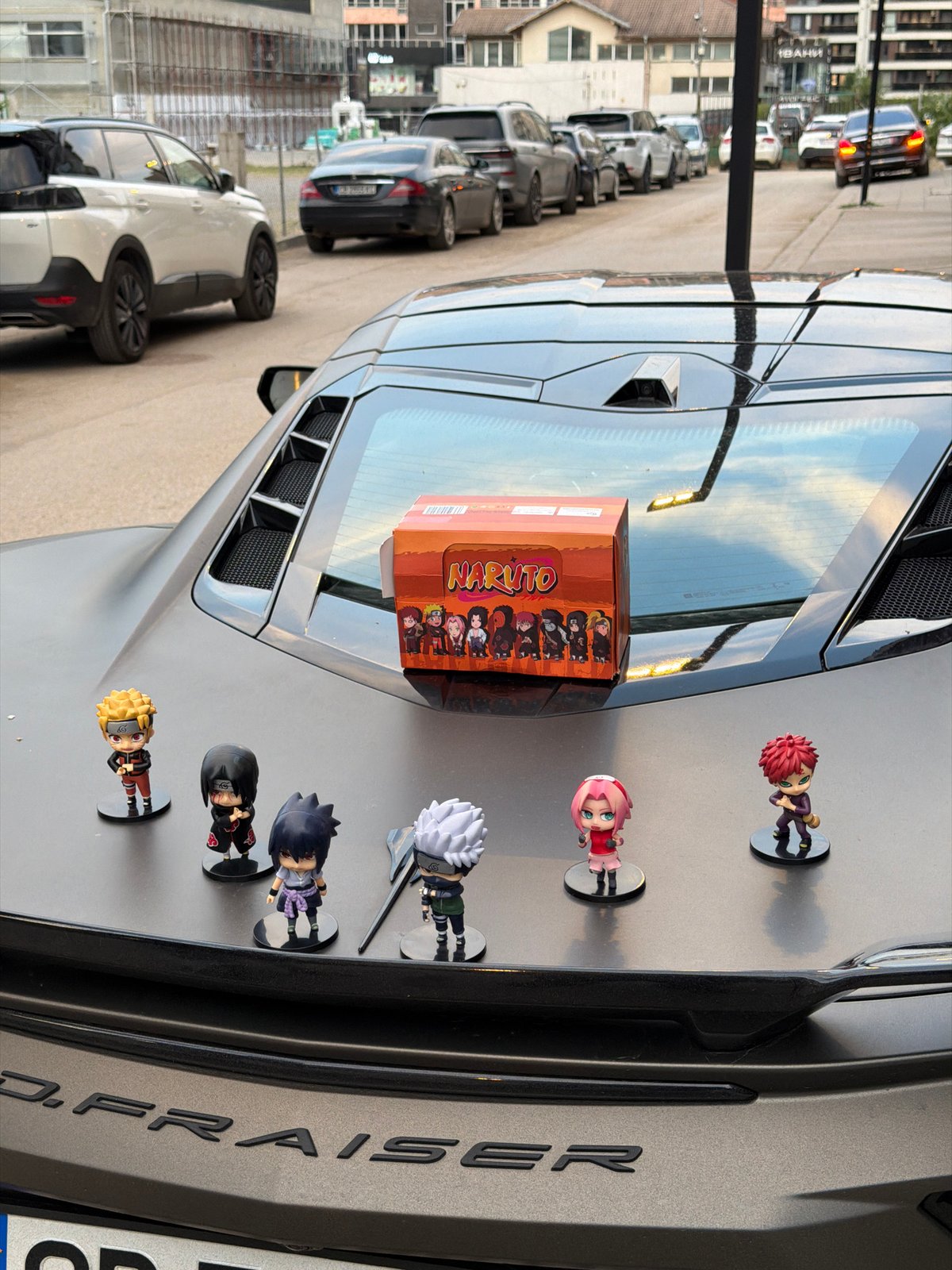 Naruto figurines displayed on a matte sports car in Sofia
