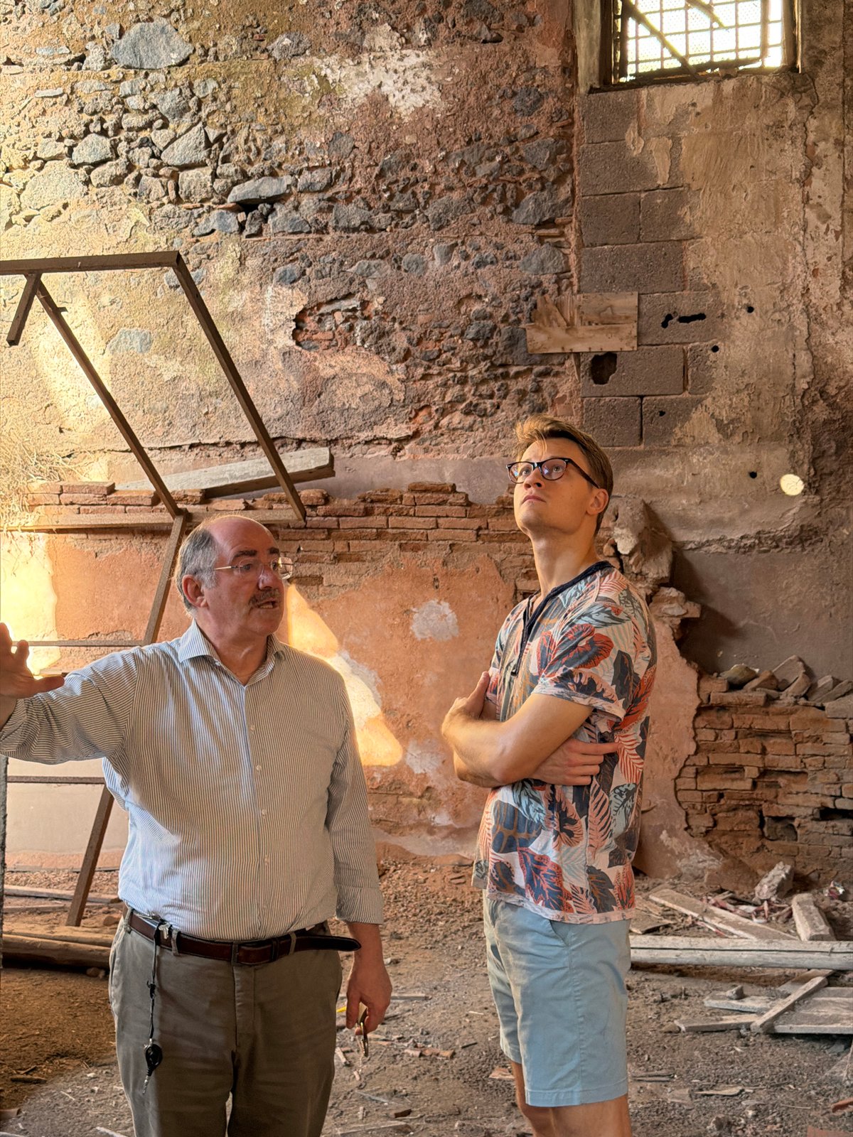 Two men explore abandoned, crumbling building in Catania