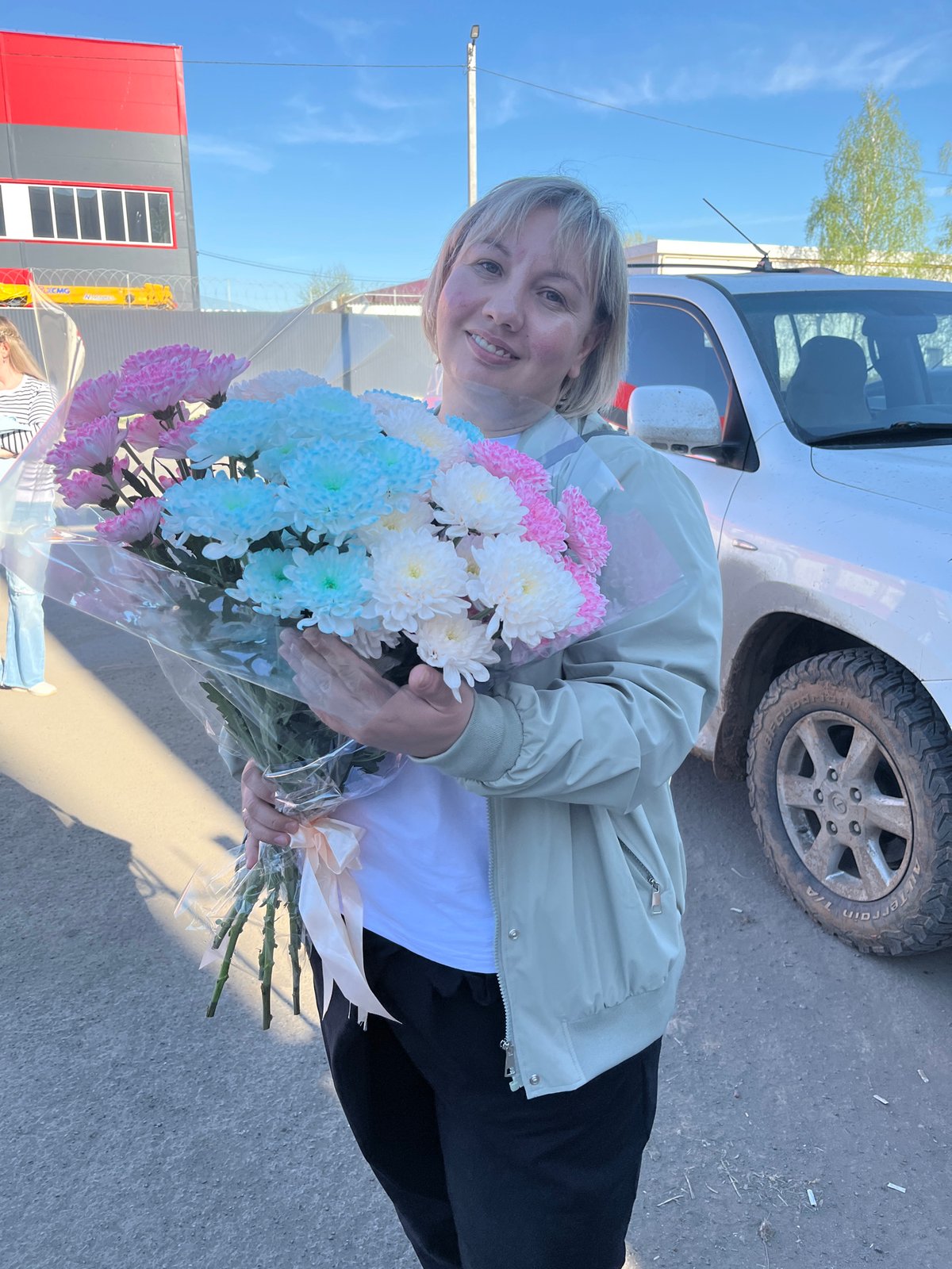 Woman holds flower bouquet in Izhevsk street scene