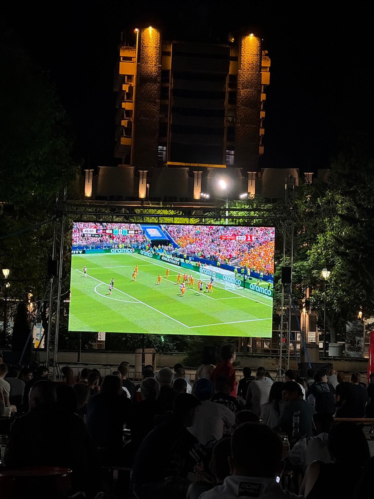 Outdoor soccer screening and a crescent moon through stormy clouds